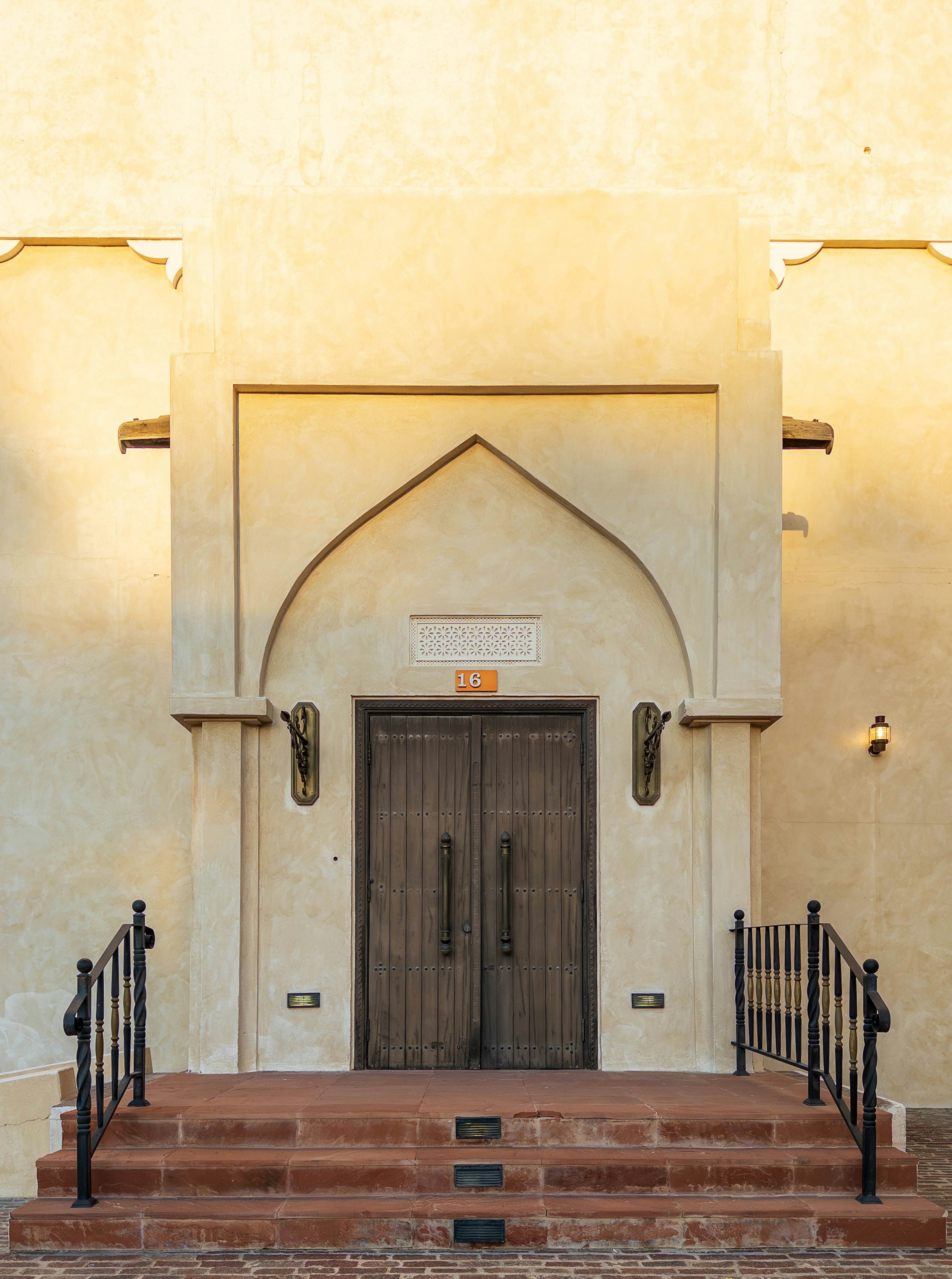 Double wooden door with Arabic design and decorative stairs