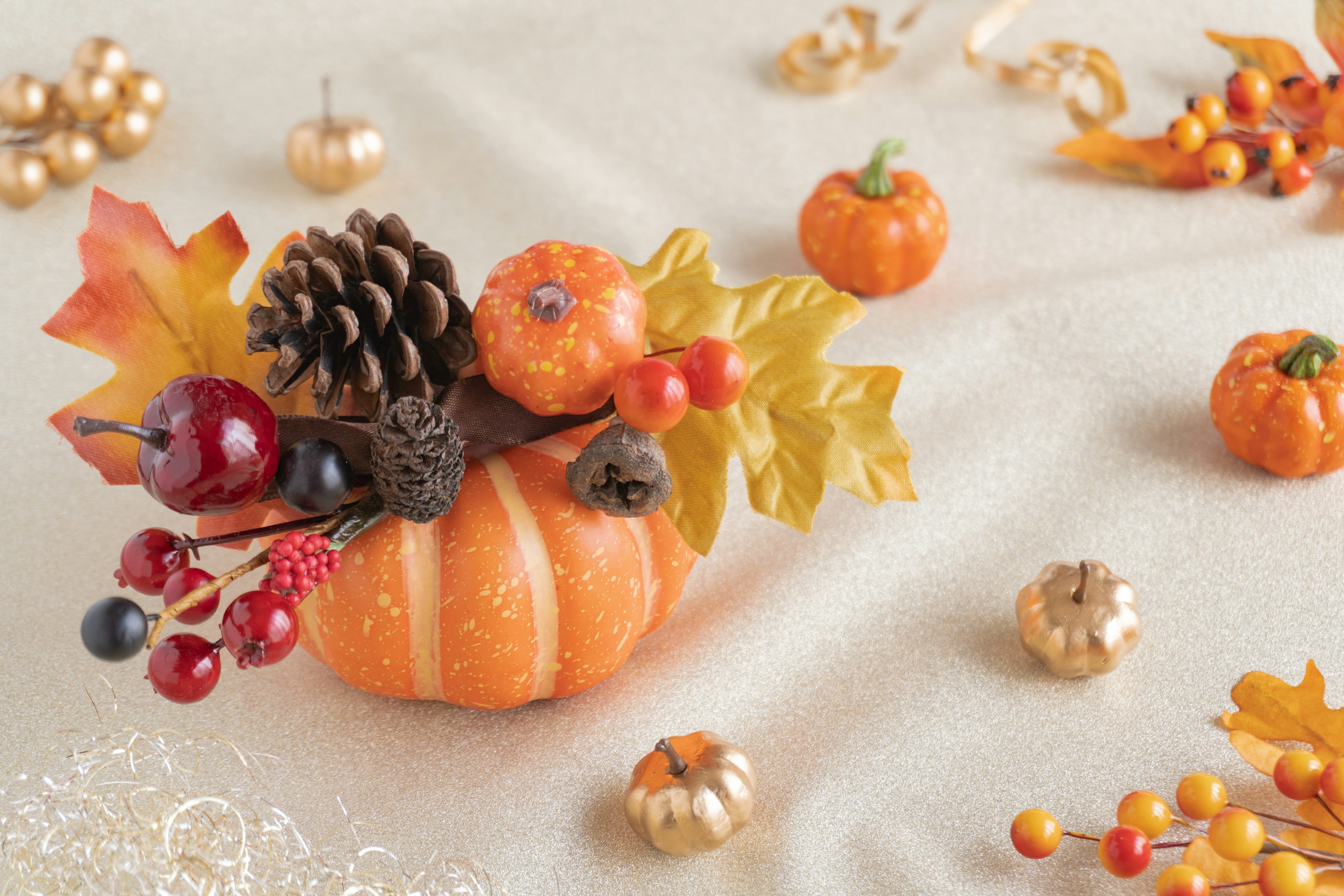 Decoración de otoño con un pequeño arreglo de calabaza y piña