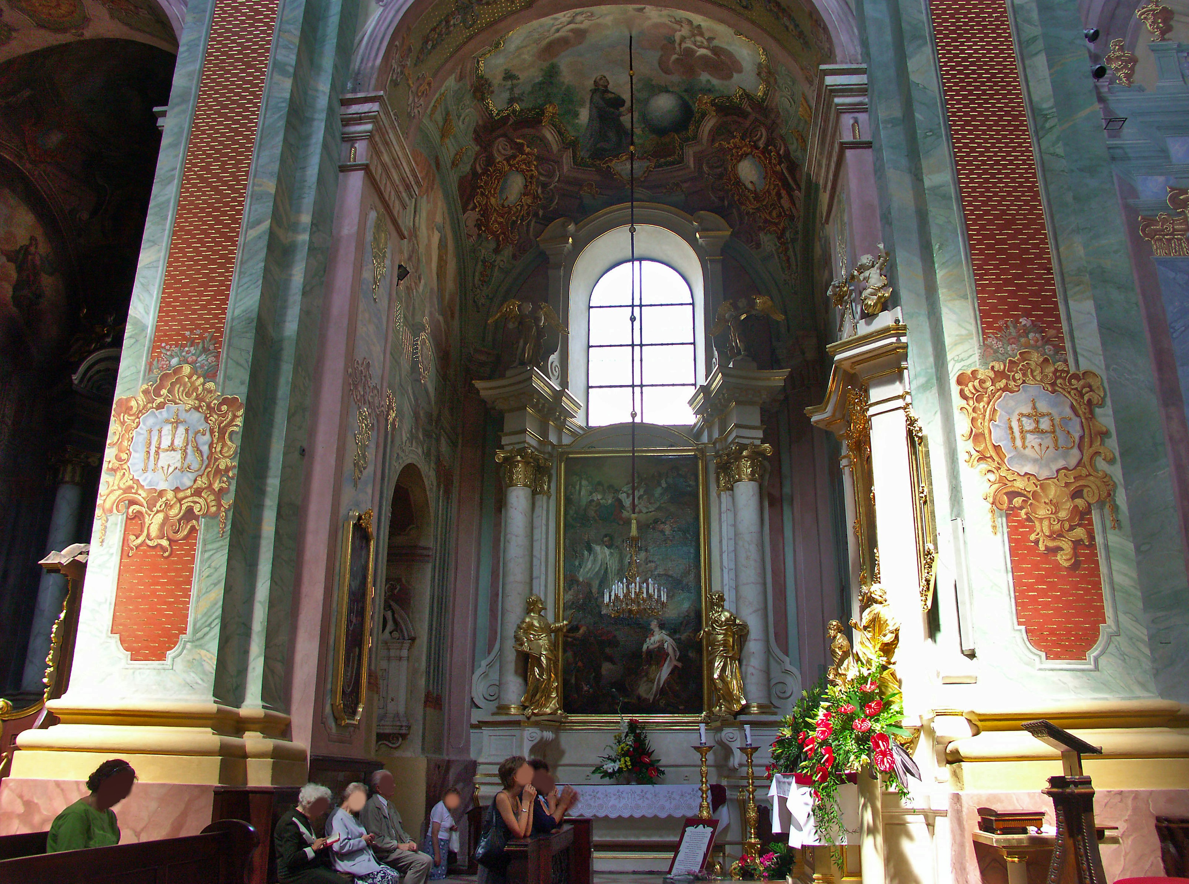 Innenansicht einer Kirche mit kunstvollen Verzierungen und religiösen Gemälden