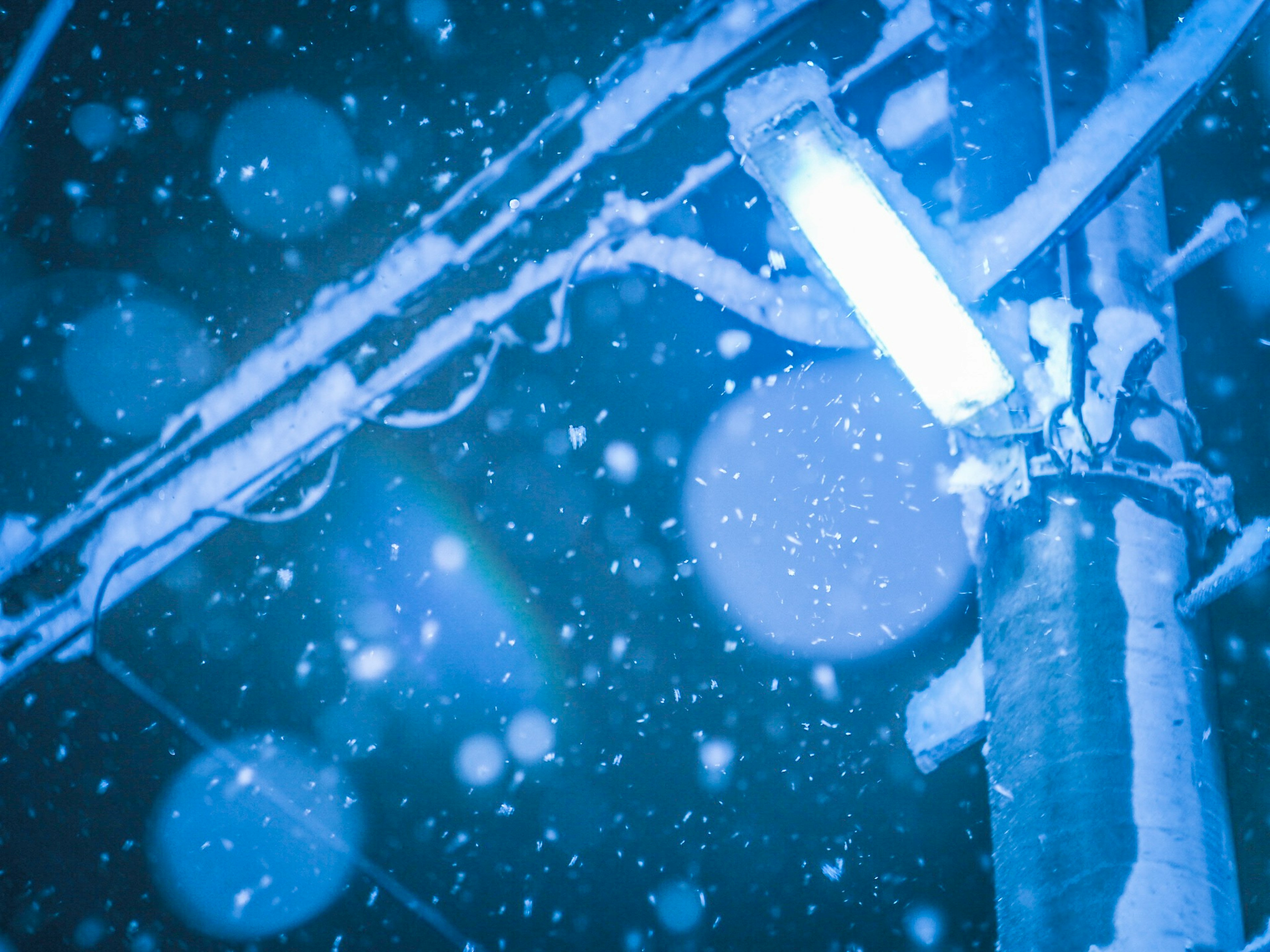 Gros plan d'un lampadaire bleu et d'un poteau électrique dans la neige