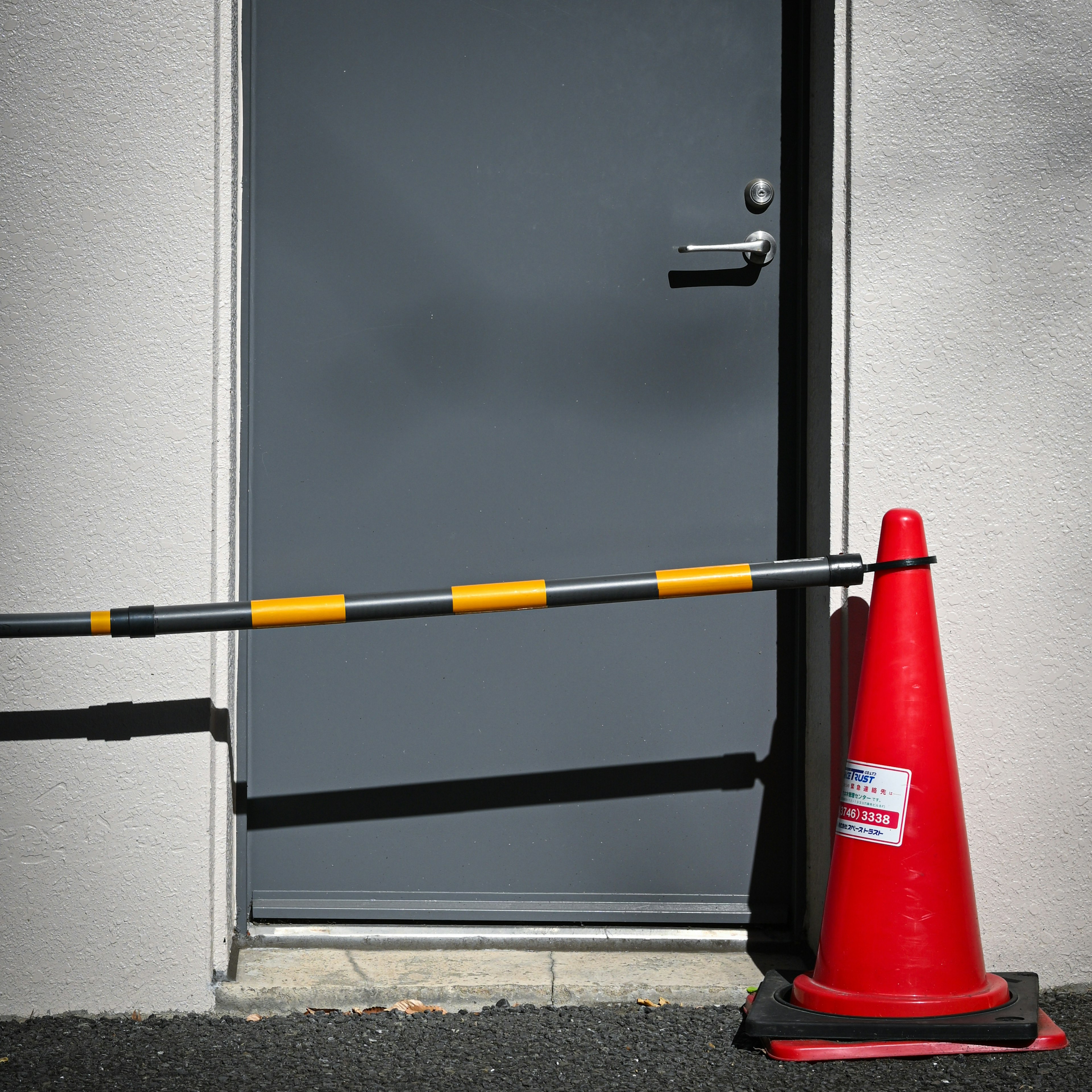 Porte grise avec un cône rouge marquant une zone restreinte