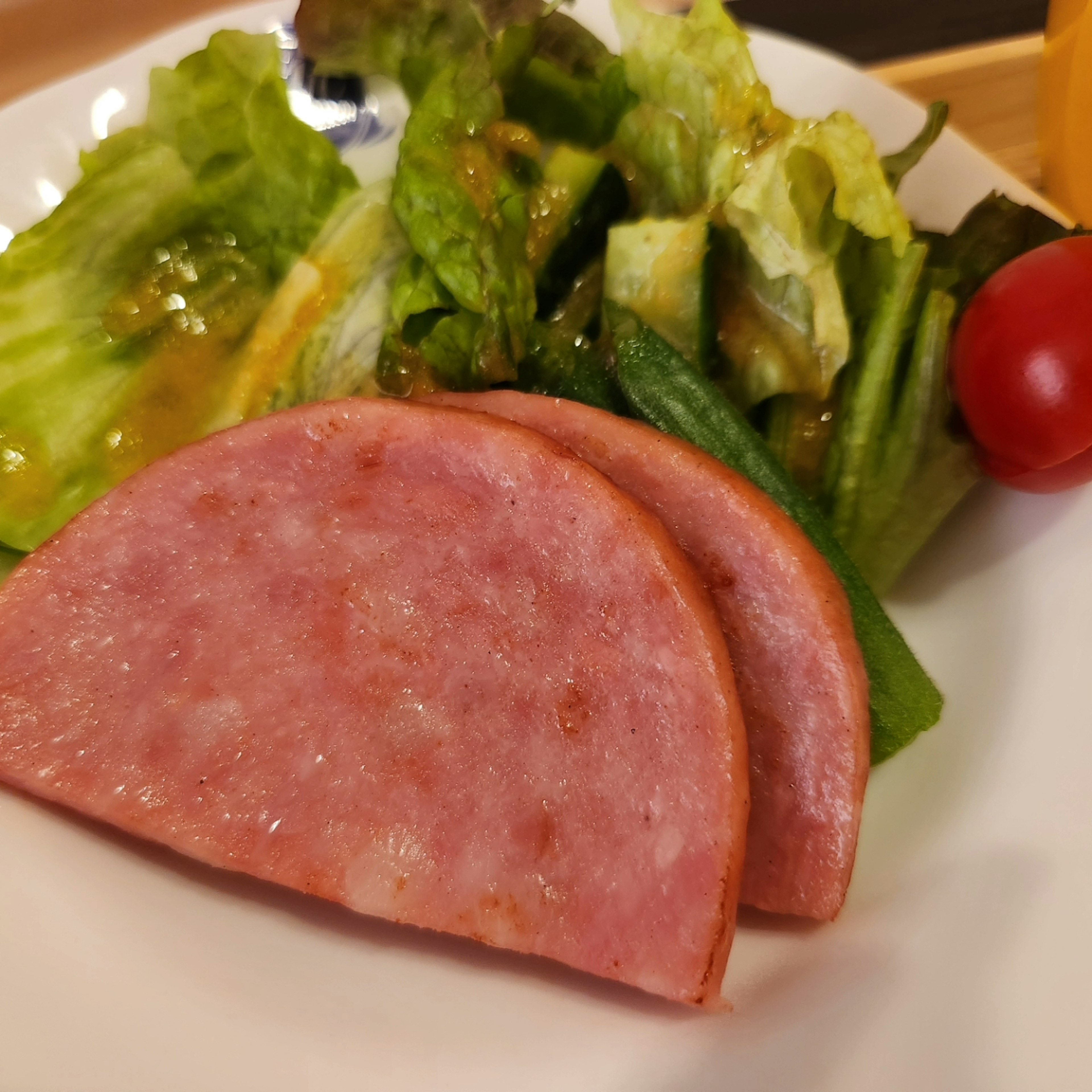 Plato de jamón en rodajas con ensalada y tomate cherry