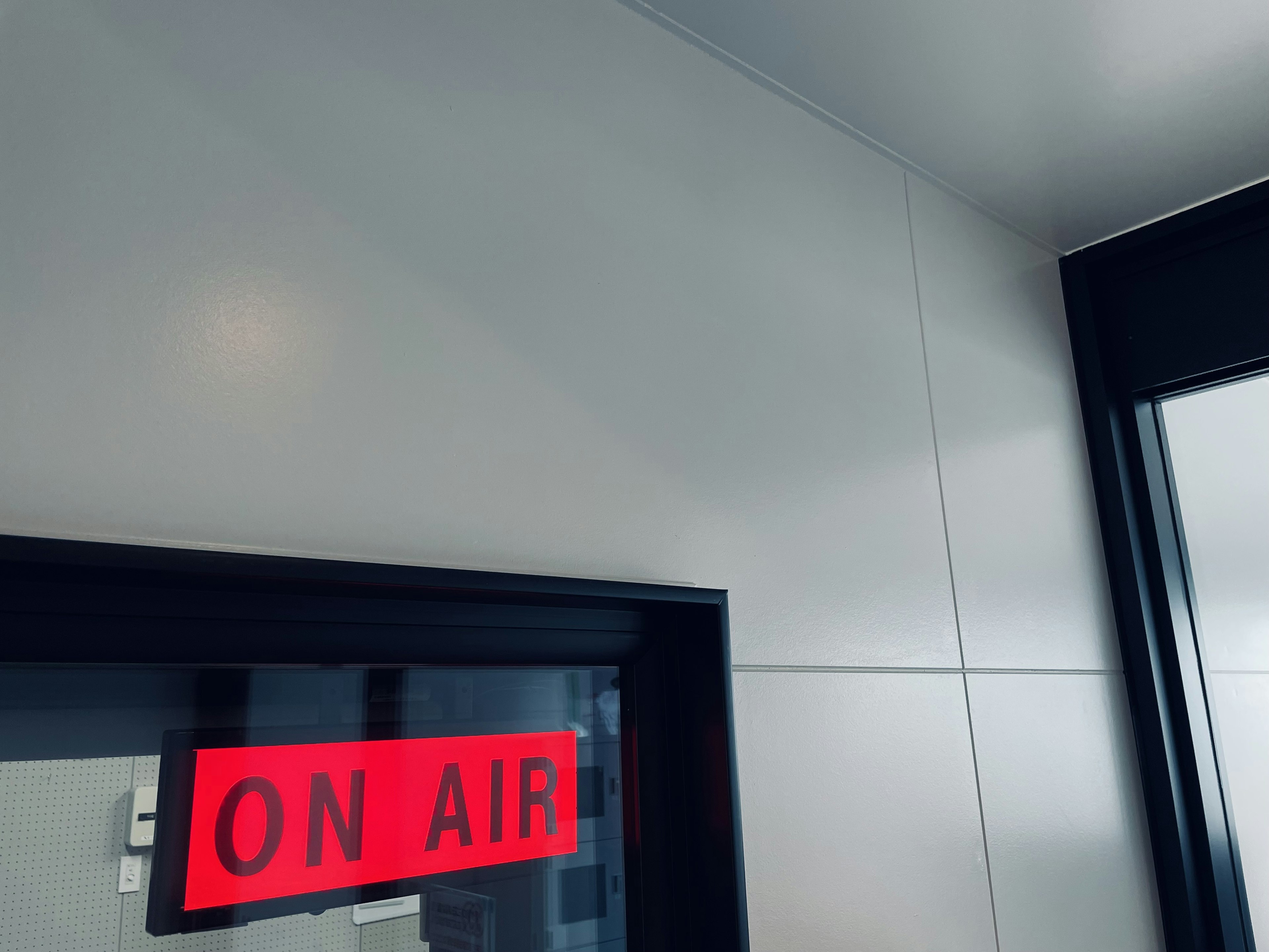 Panneau rouge 'ON AIR' à l'entrée du studio