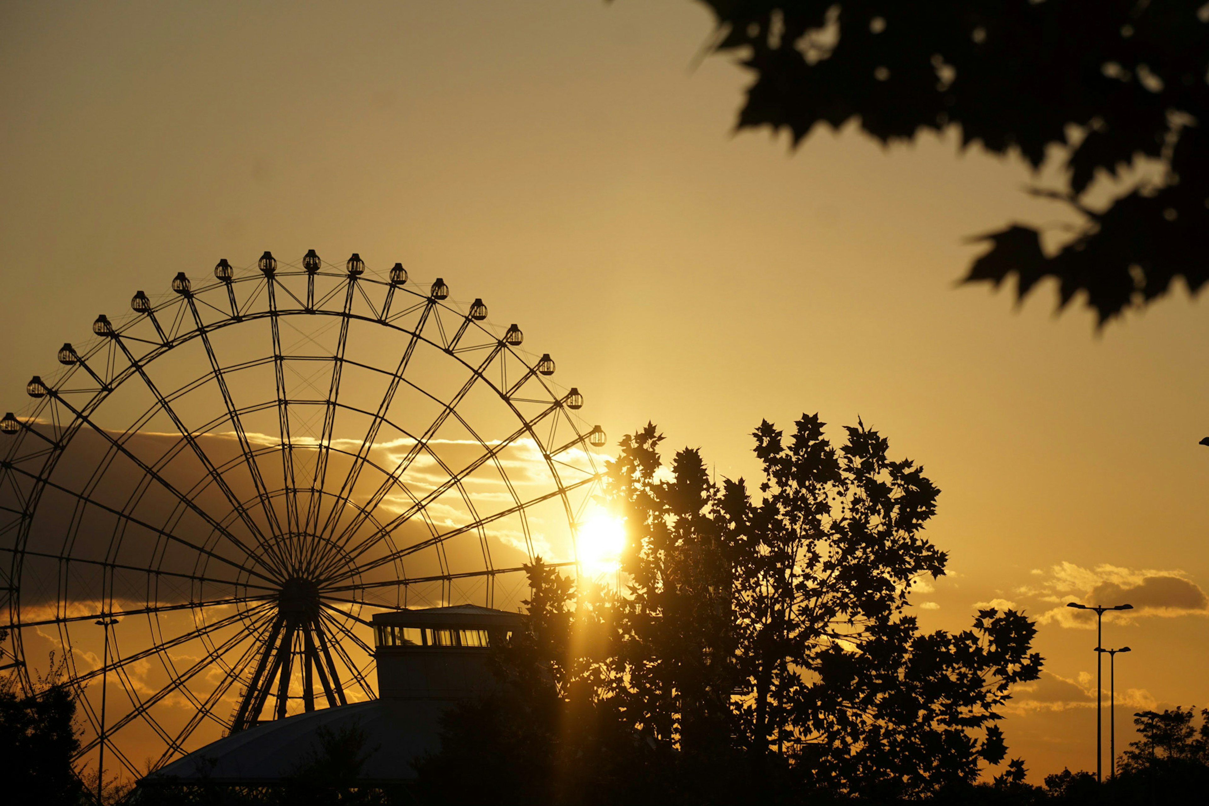 Silhouette of a Ferris wheel against the sunset