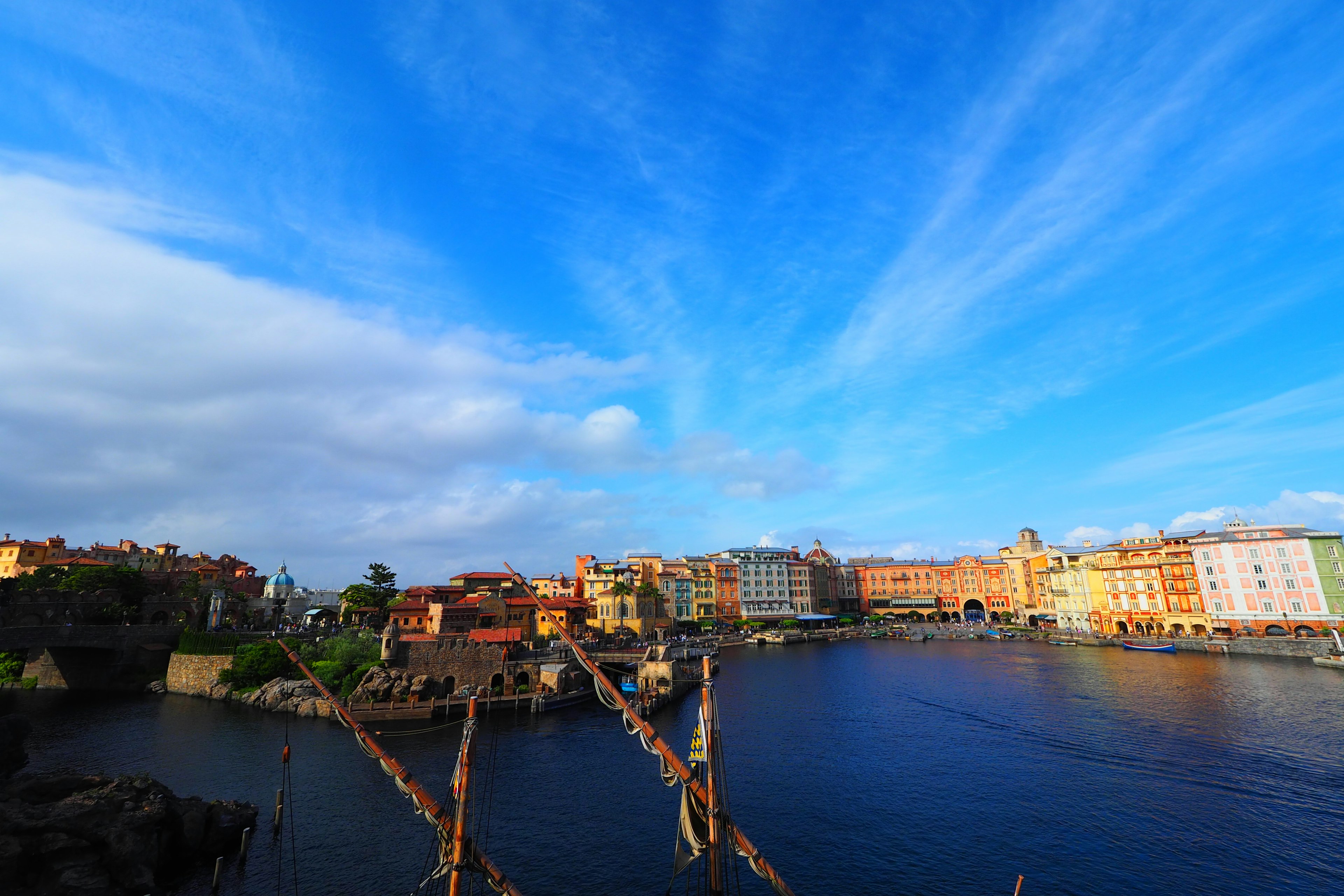 Coastal cityscape under a blue sky with wispy clouds