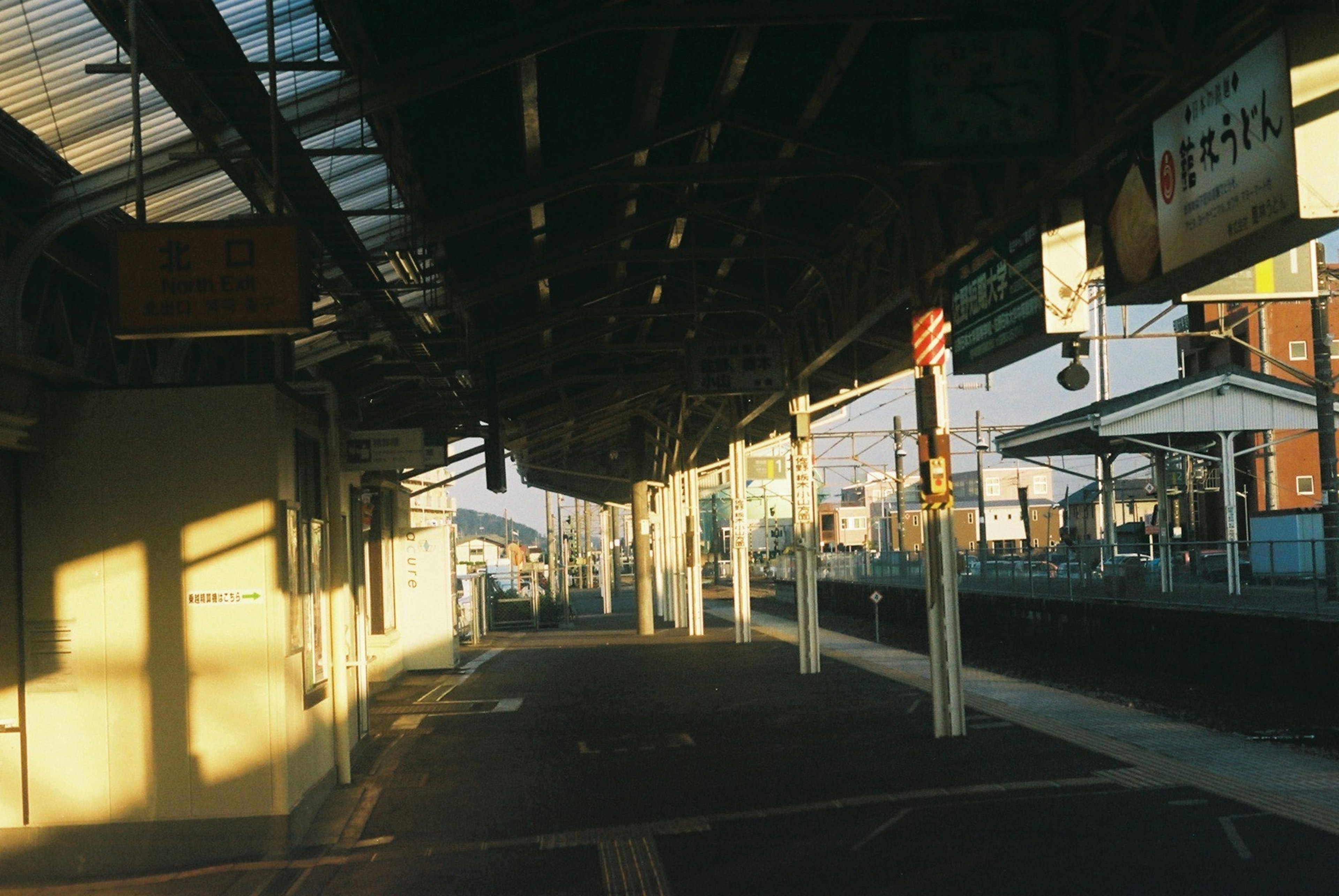 Quiet train station platform illuminated by sunset light