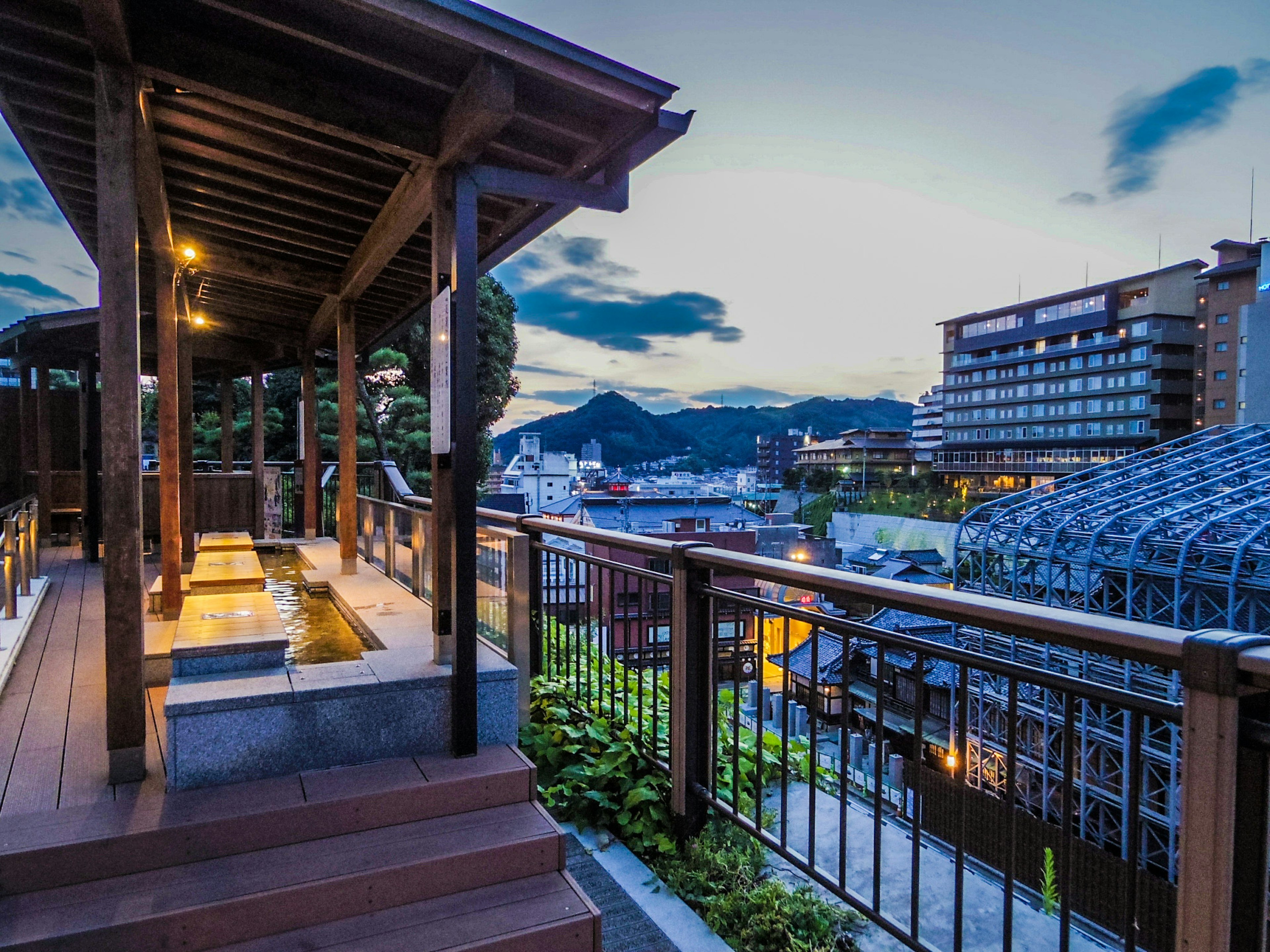 Vue pittoresque depuis une terrasse de source chaude avec montagnes et lumières de la ville