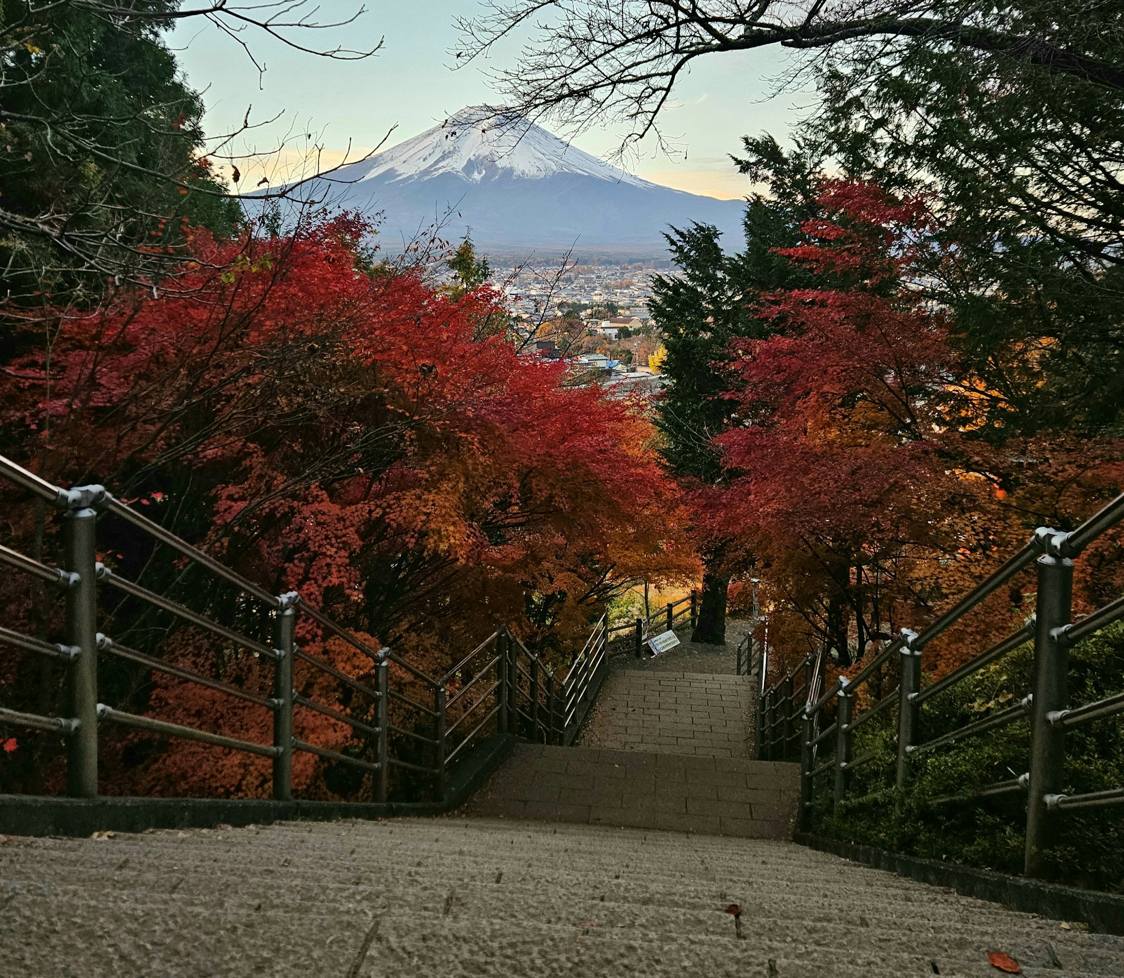 Vista escénica de escaleras rodeadas de follaje otoñal y el monte Fuji al fondo