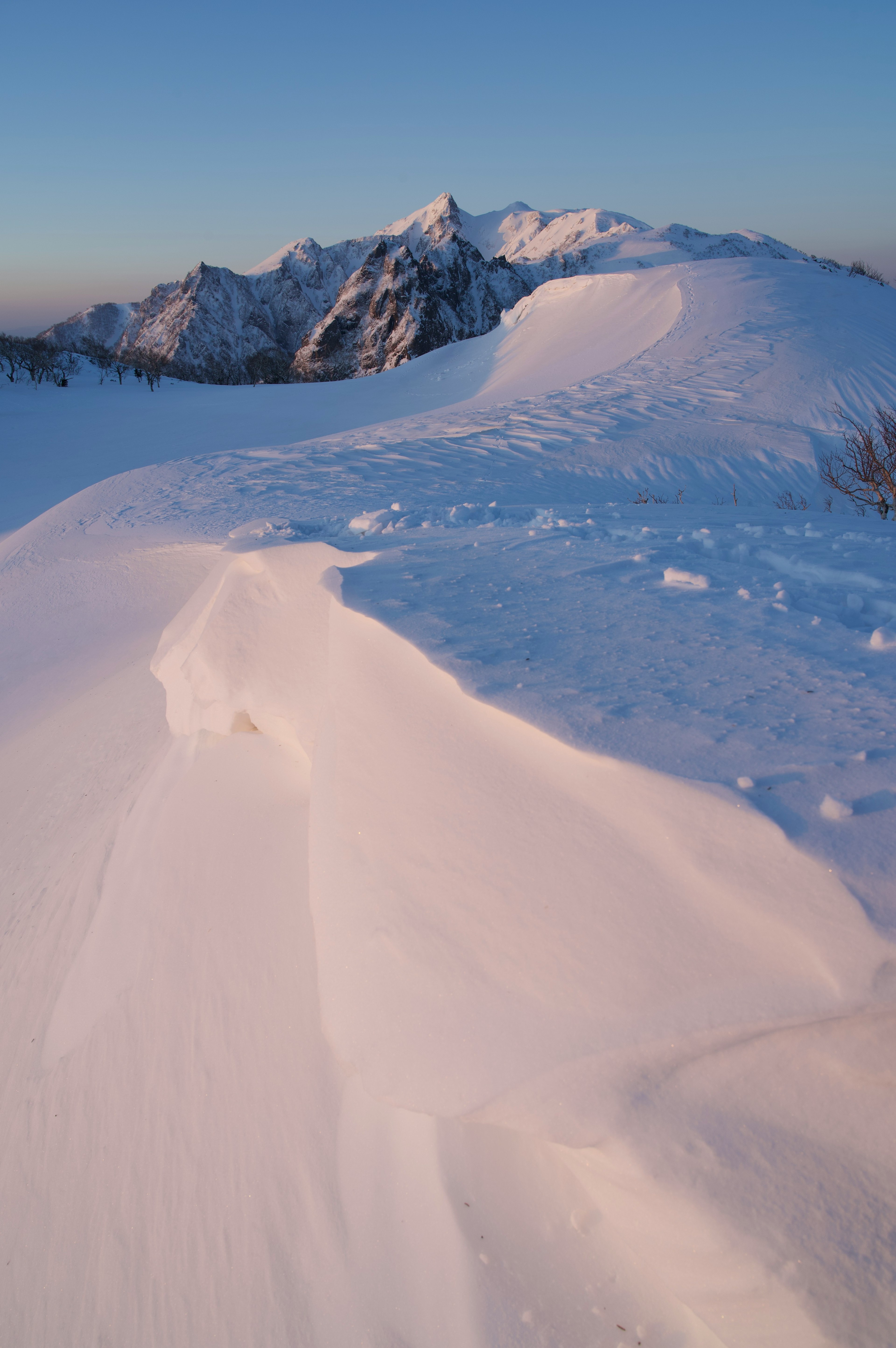 Snow-covered mountains with a clear blue sky