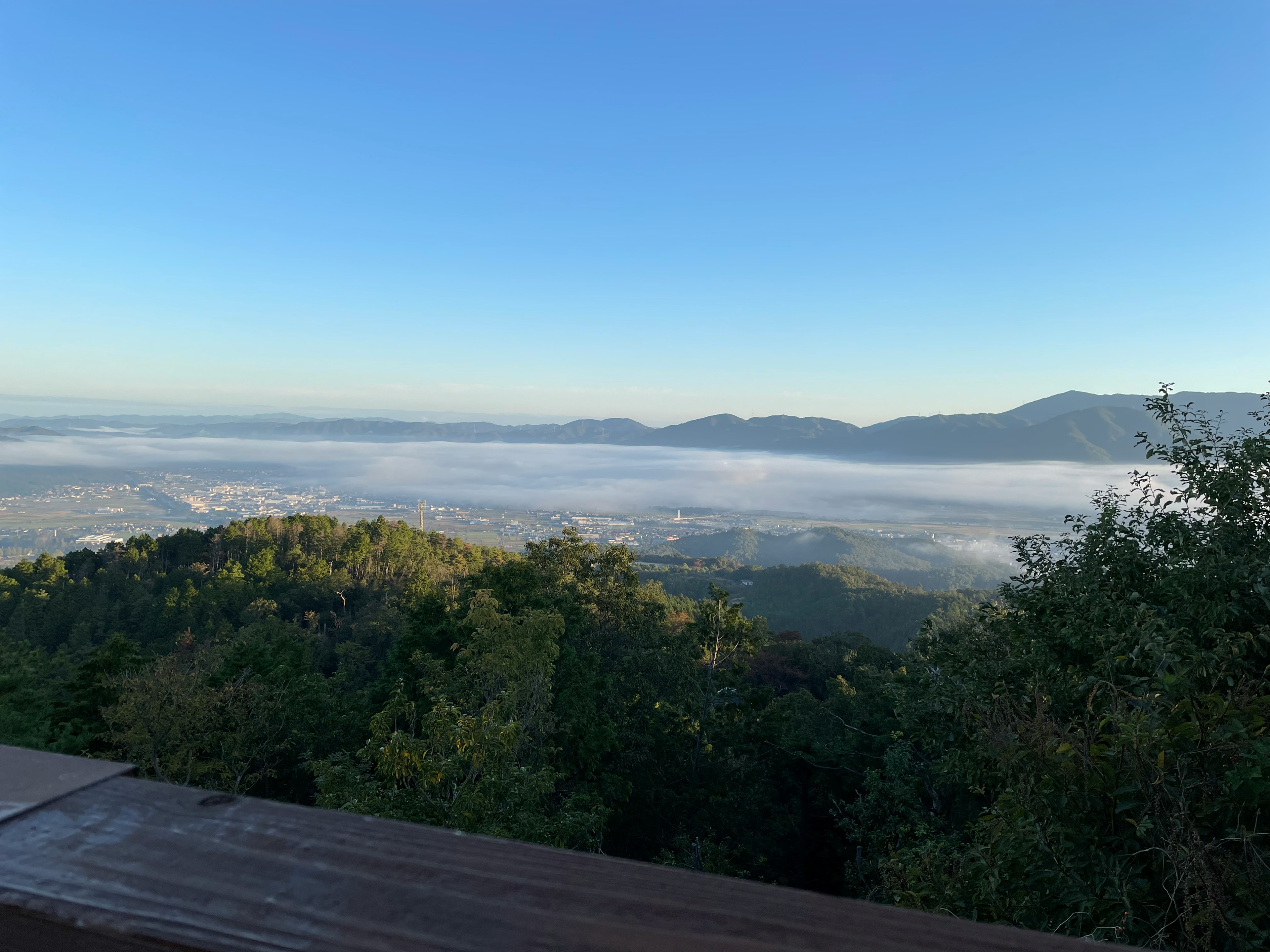 Panoramablick auf Berge, die im Nebel gehüllt sind, mit klarem blauen Himmel