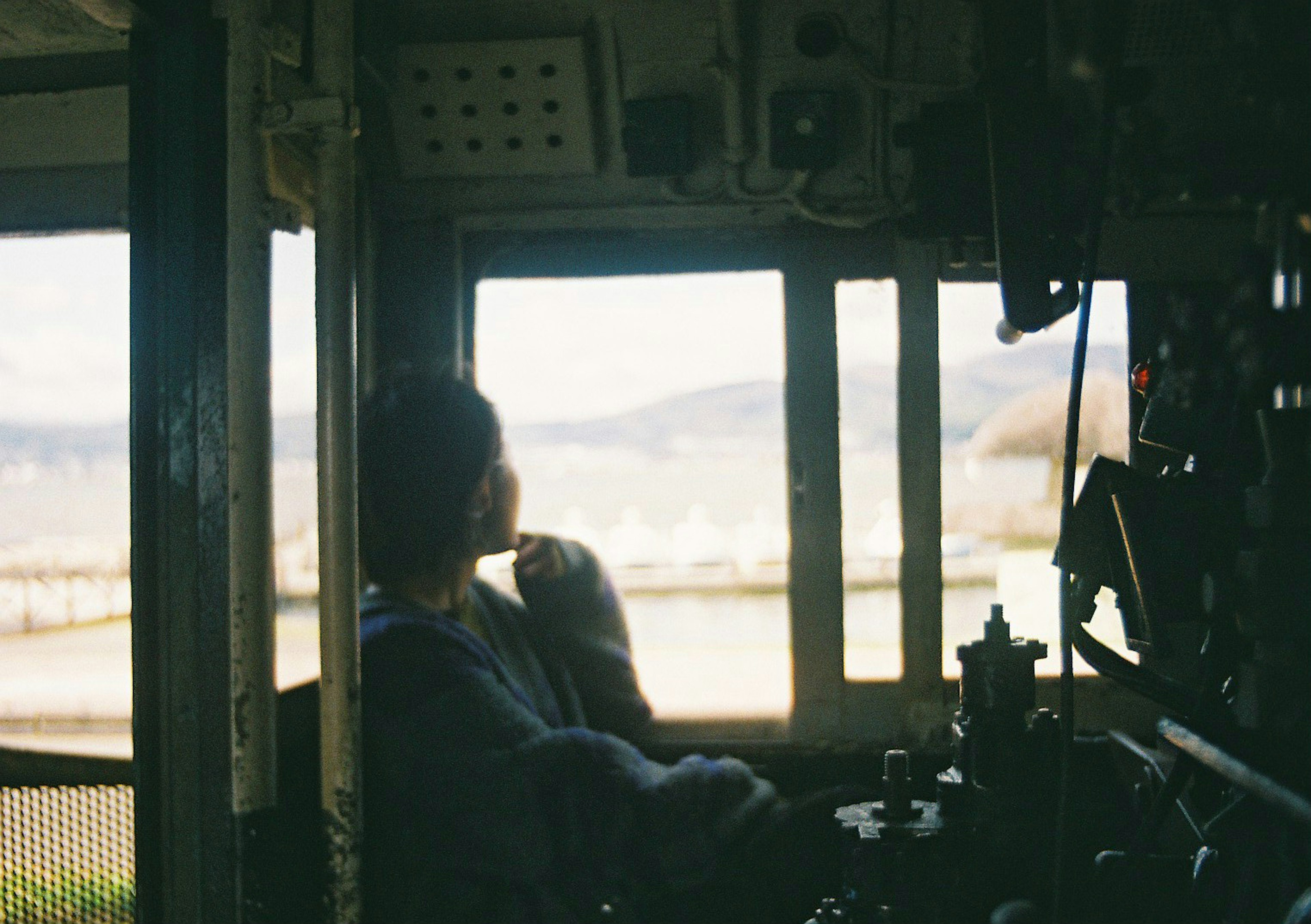 運転室から外を眺める人のシルエットと風景