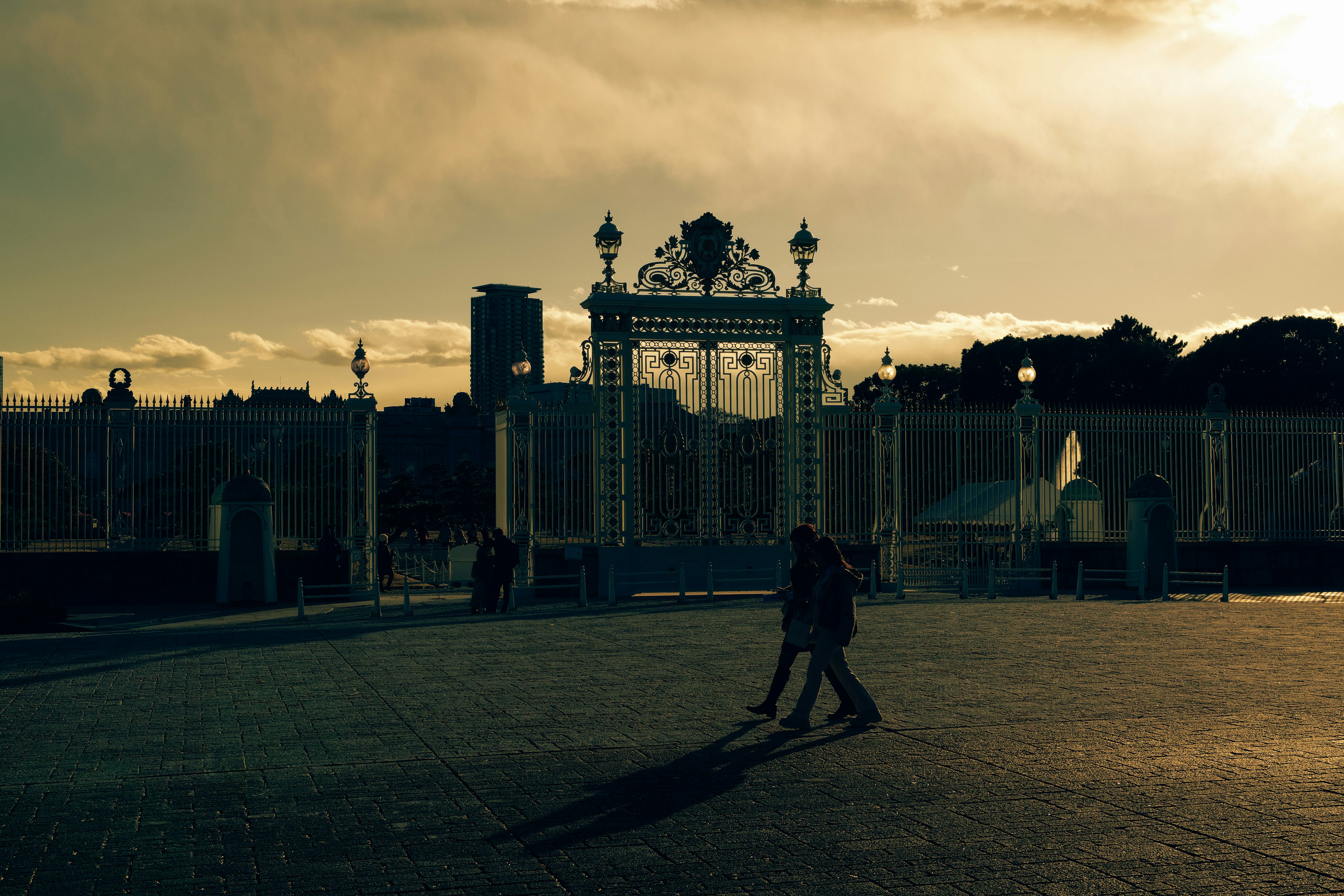 Silhouette d'un couple marchant devant une porte au coucher du soleil