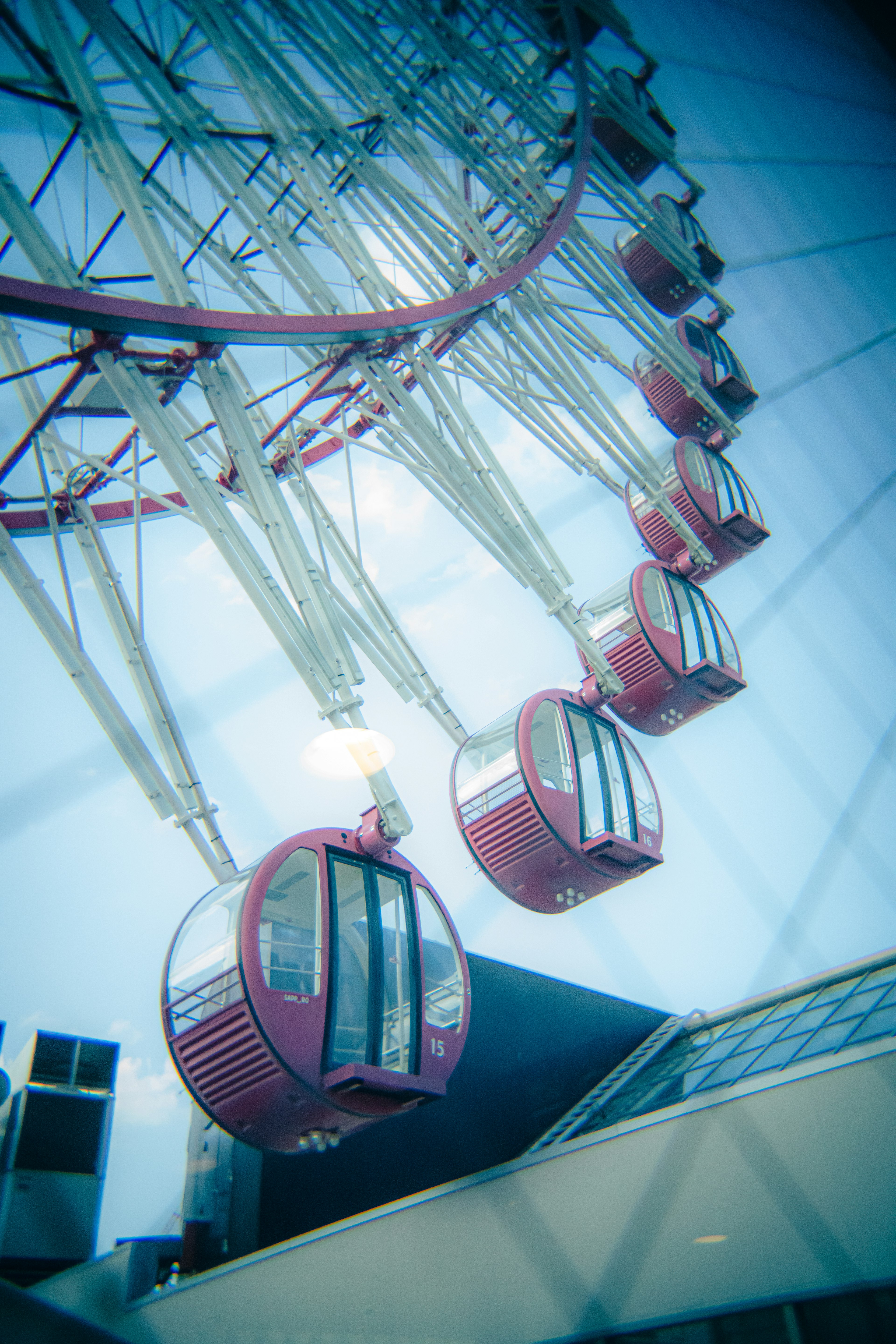 Ferris wheel cabins arranged under a blue sky