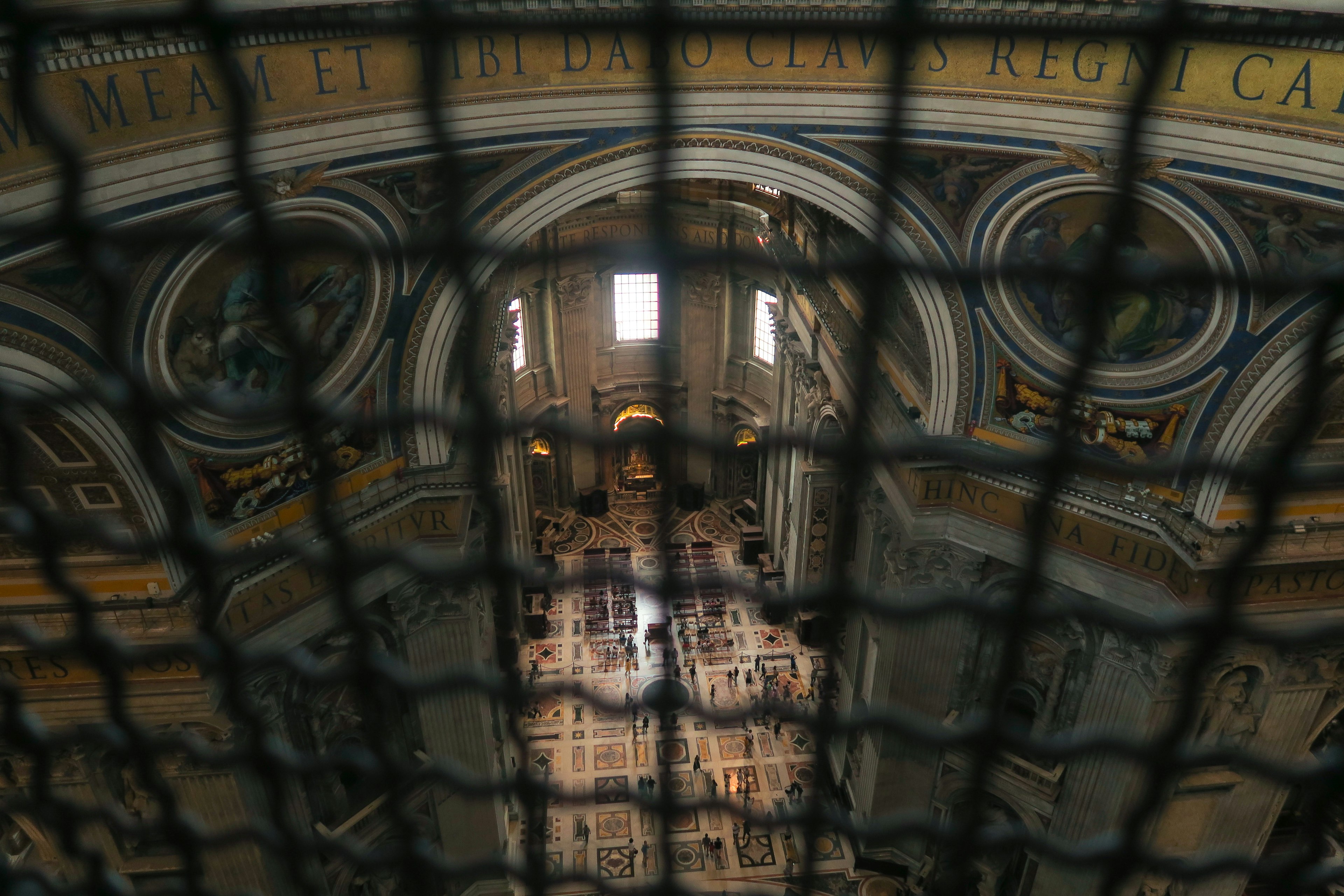 Vista dell'interno della basilica di San Pietro attraverso una griglia metallica