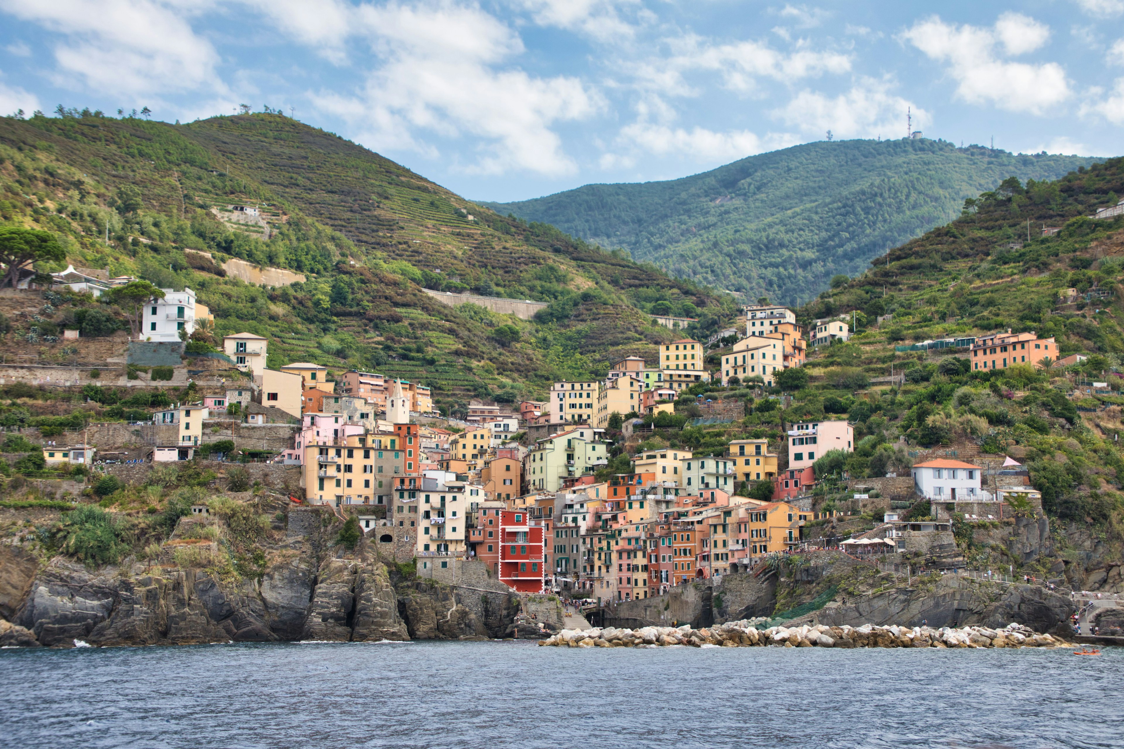 Scenic view of a colorful village along the coastline with houses on hills