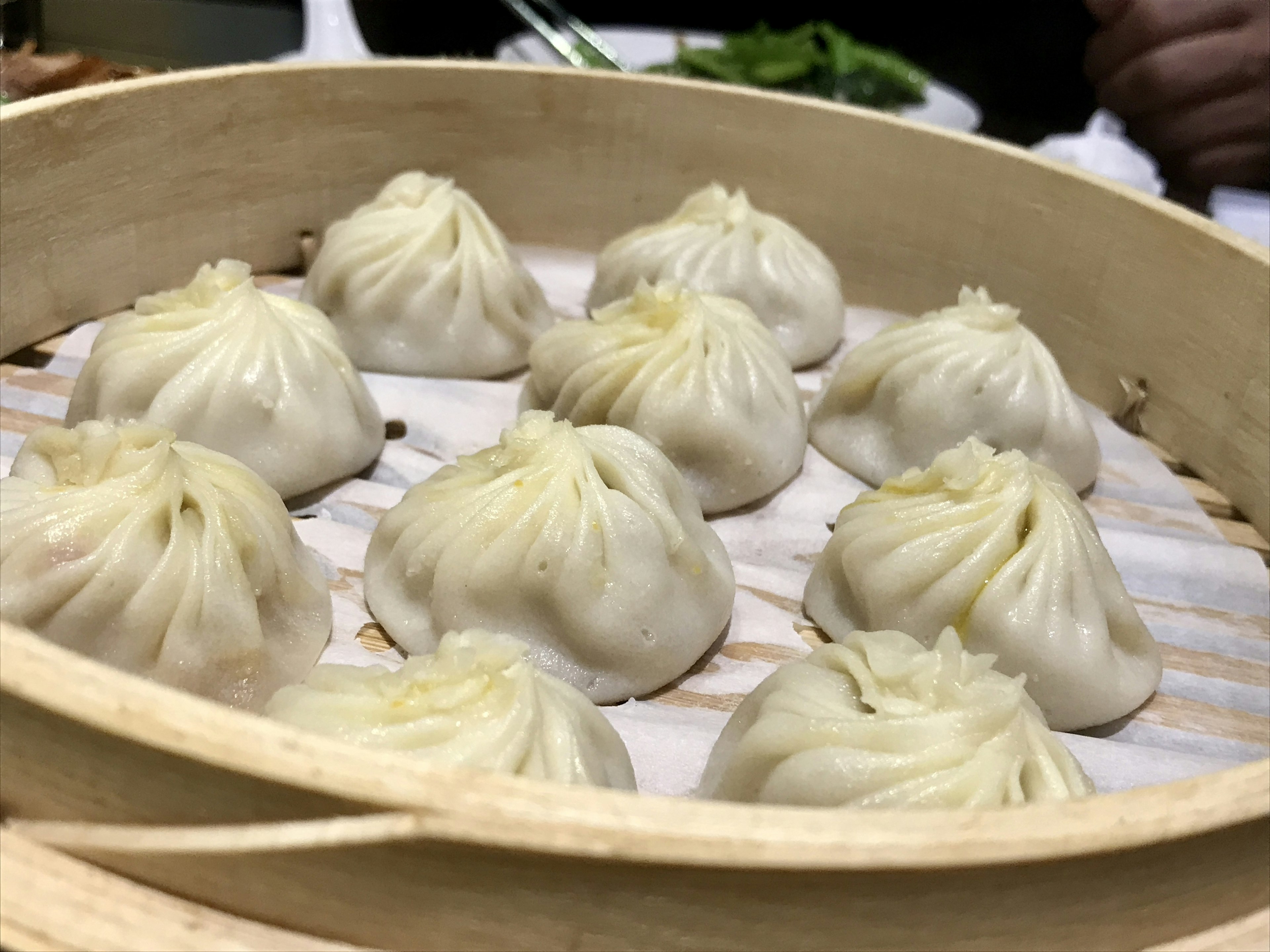 Ten steamed dumplings arranged in a bamboo steamer