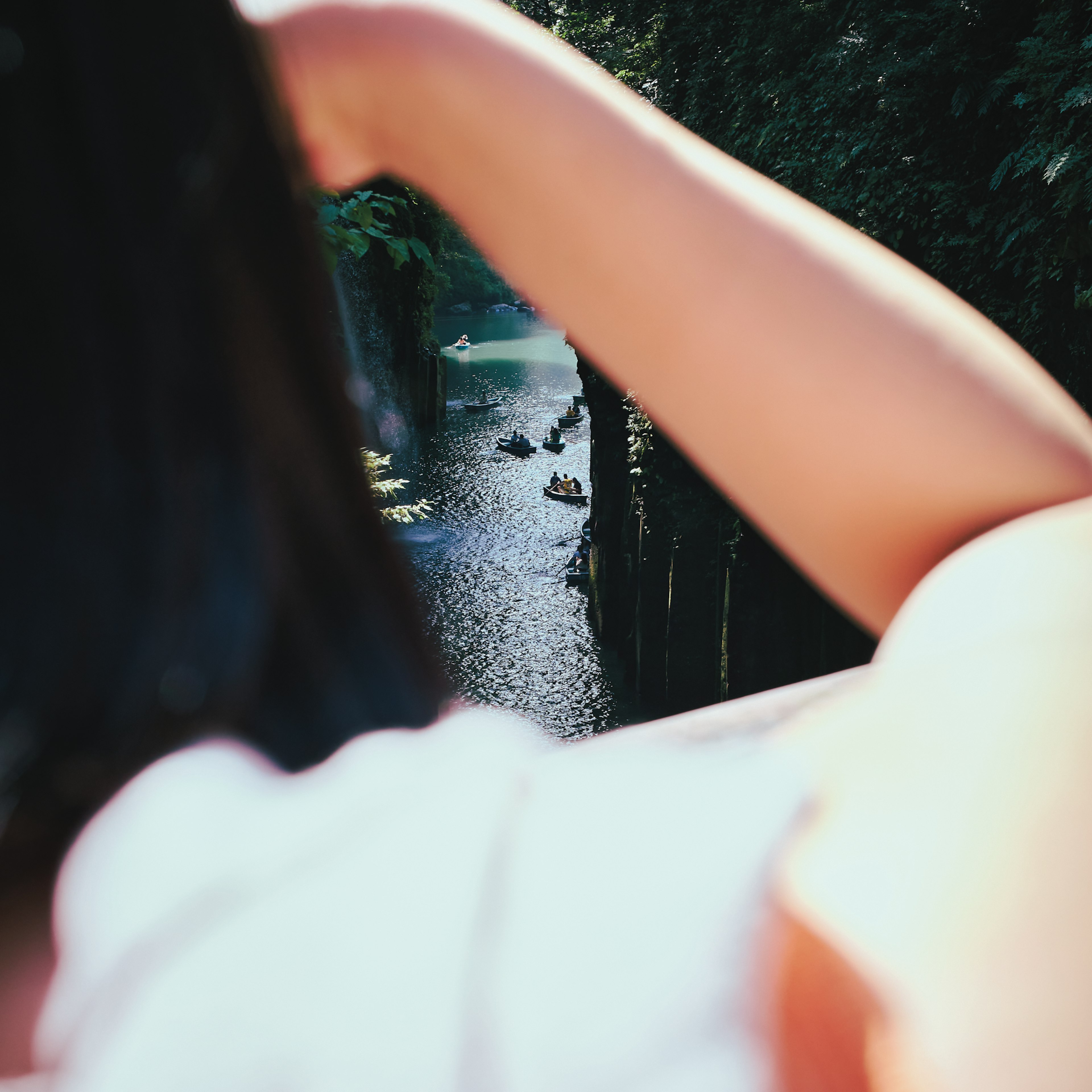 Vue arrière d'une femme surplombant une rivière entourée d'arbres verts