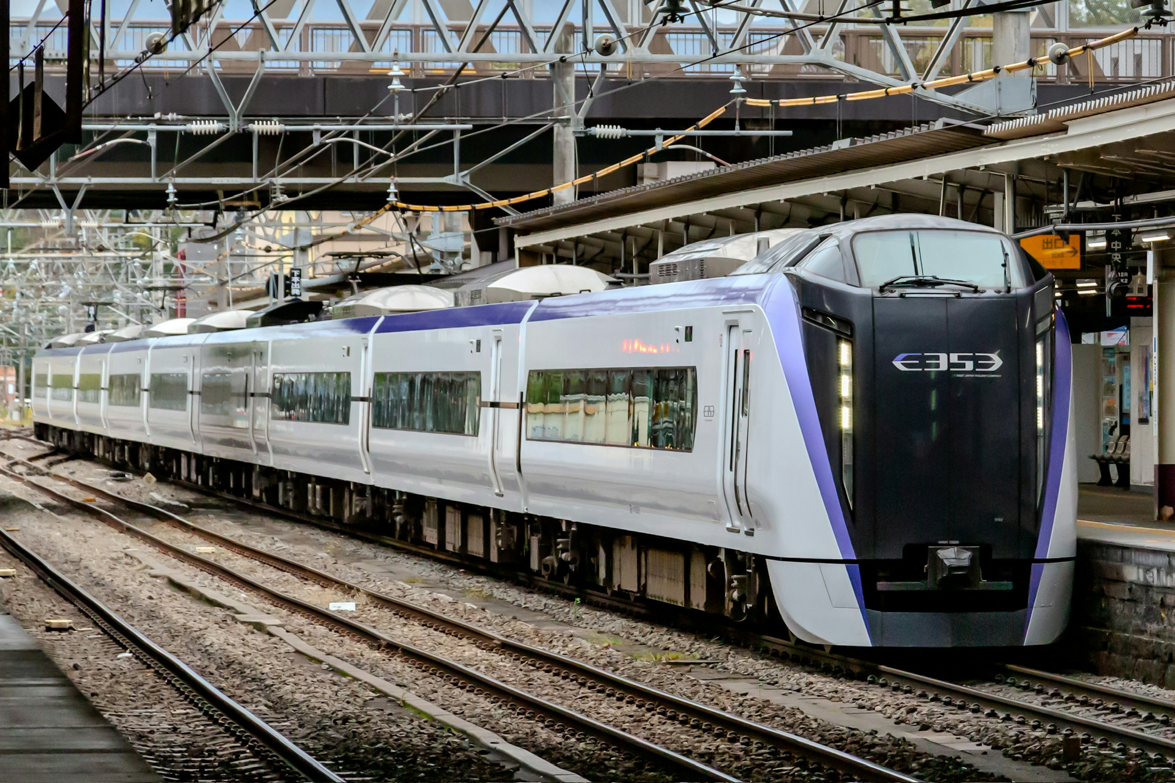 A modern train with a sleek design at a railway station