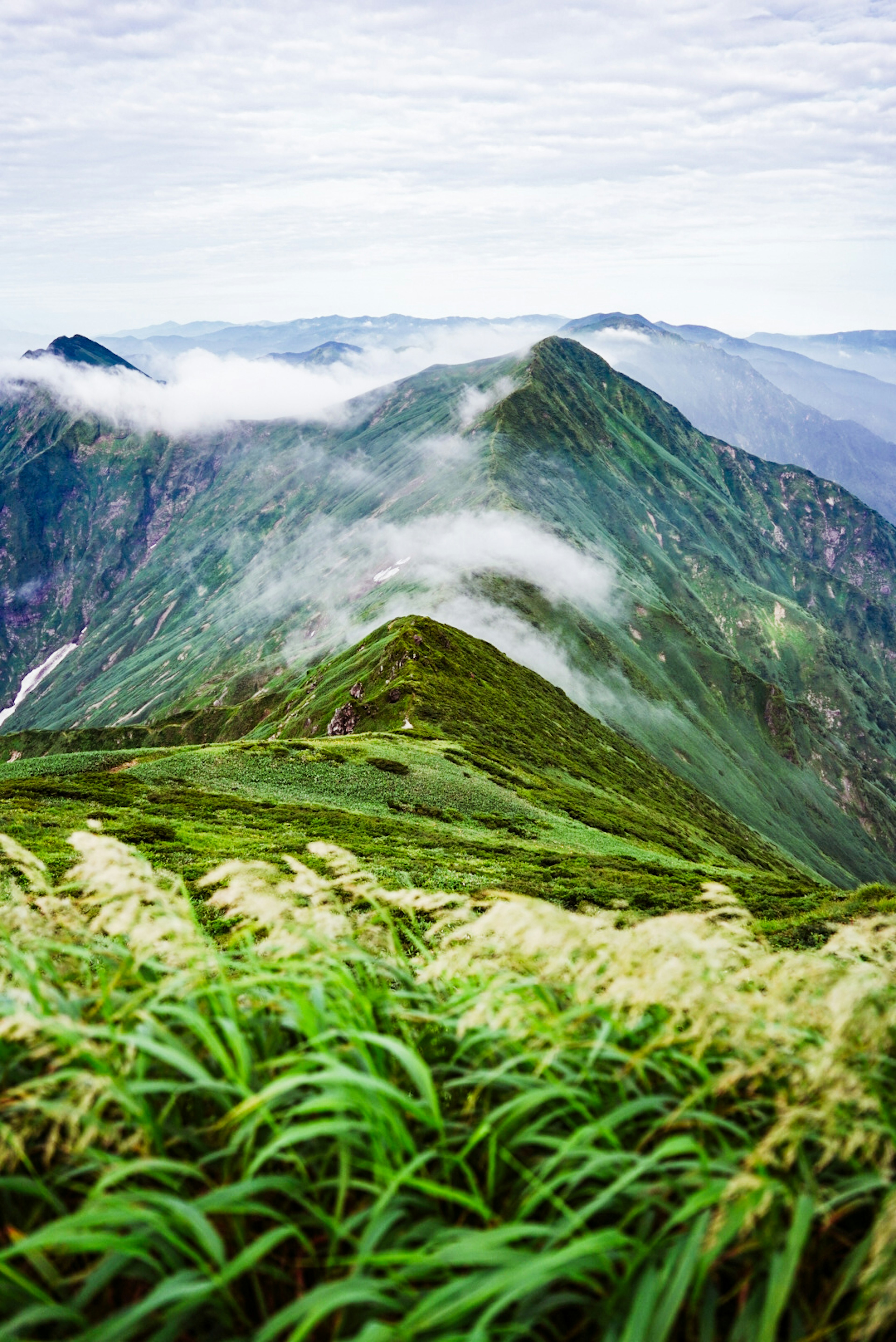 Foto de montañas verdes con nubes al fondo