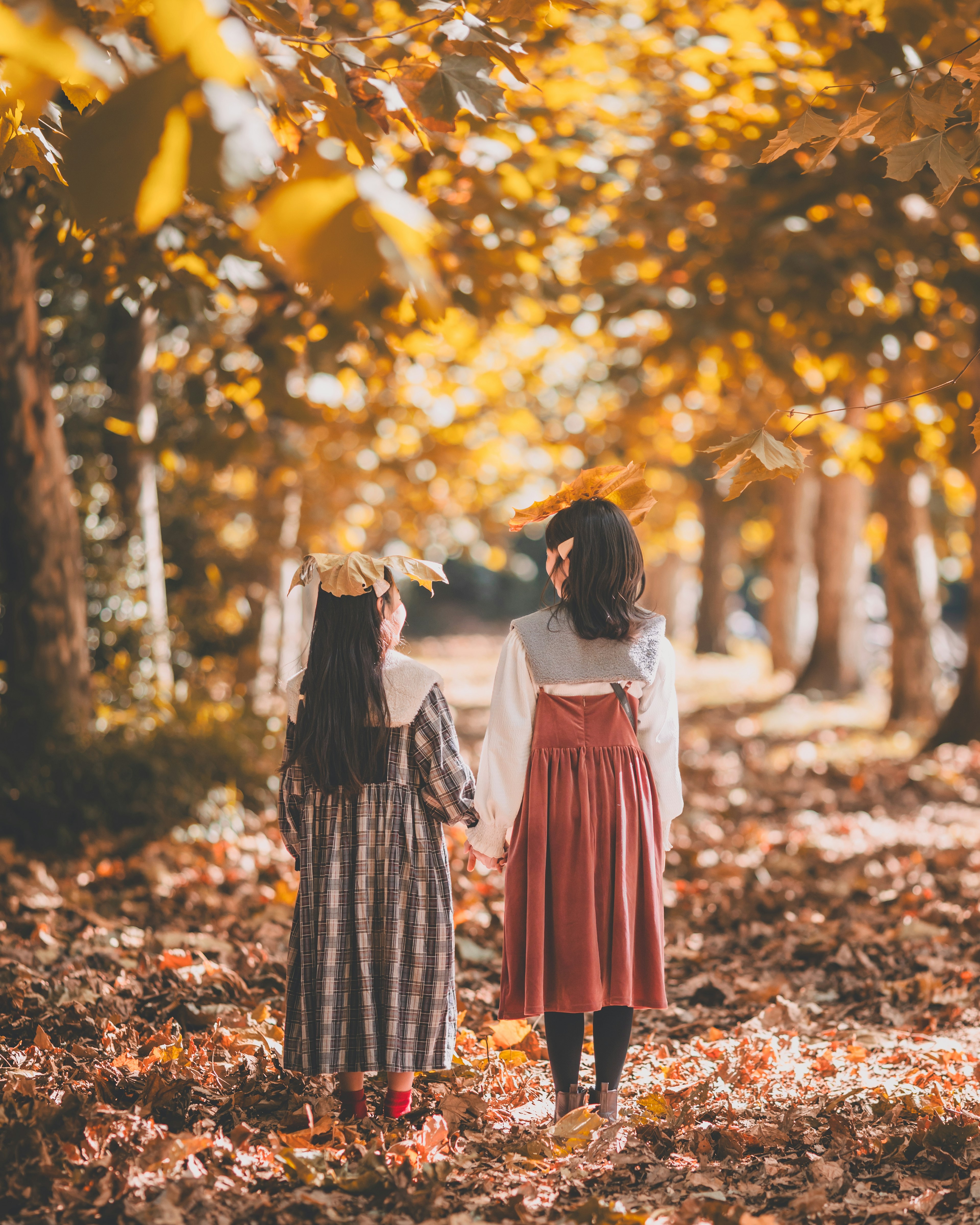 Dos niñas caminando en un parque de otoño