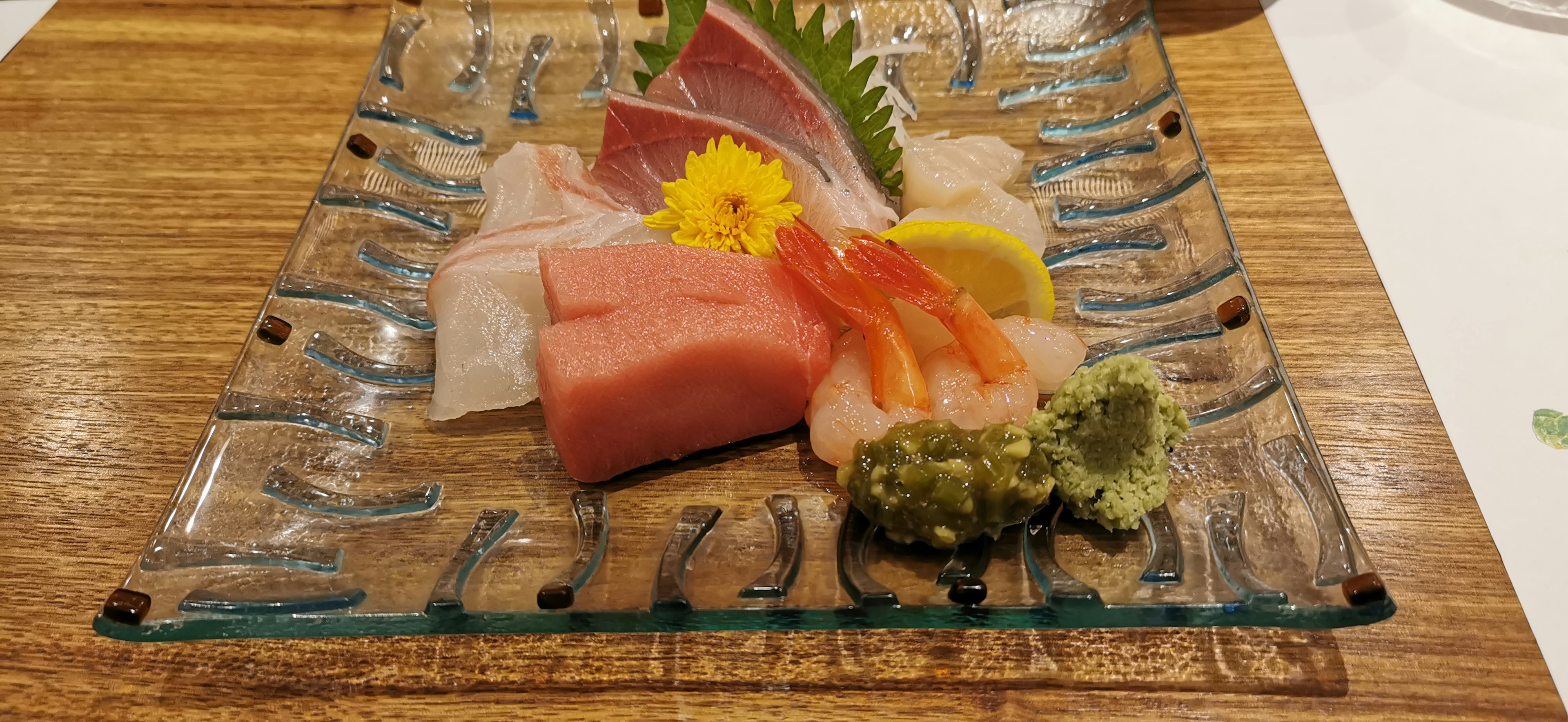 Sashimi coloré disposé sur une assiette décorative