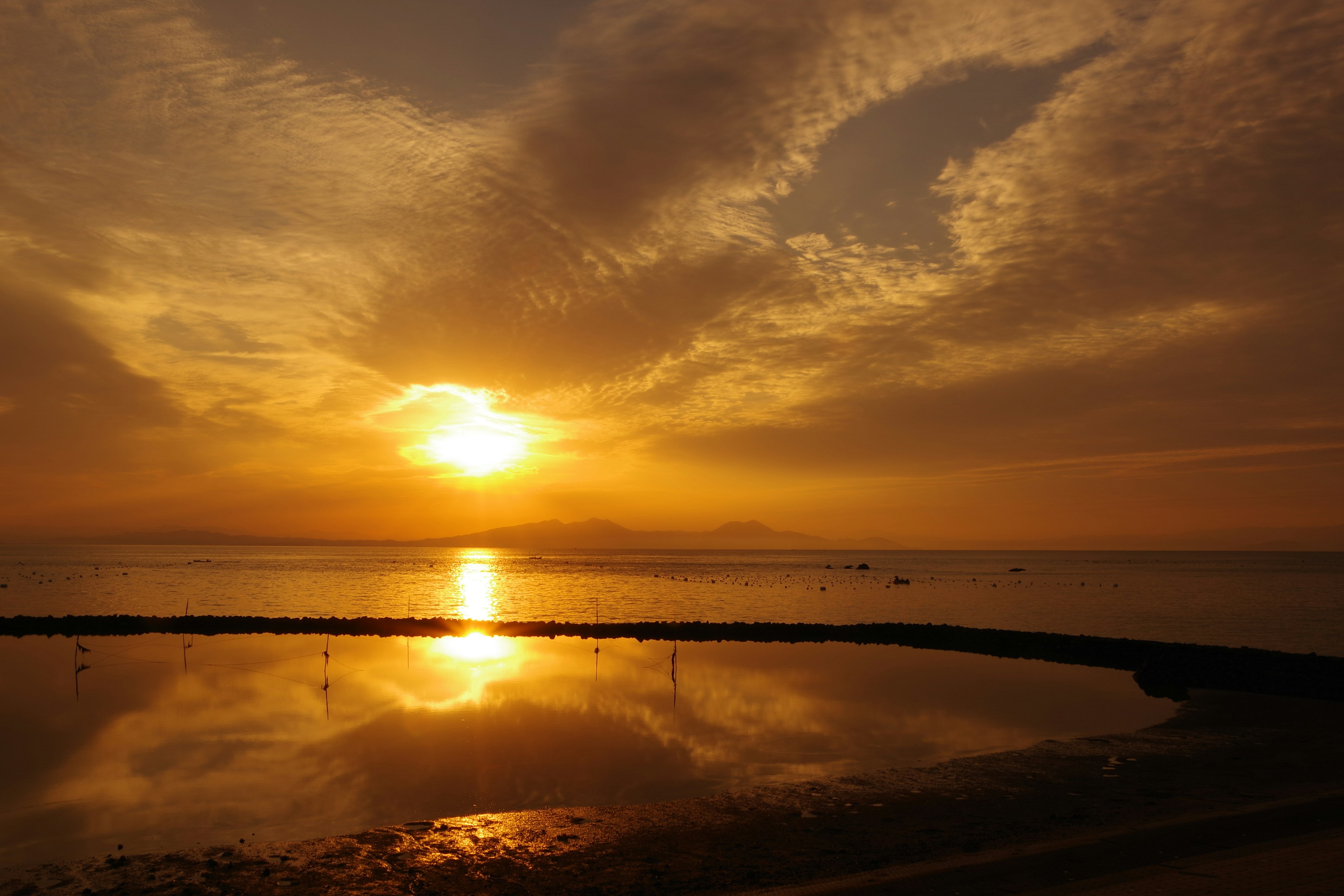 Bellissimo tramonto sul mare che riflette una luce arancione sull'acqua