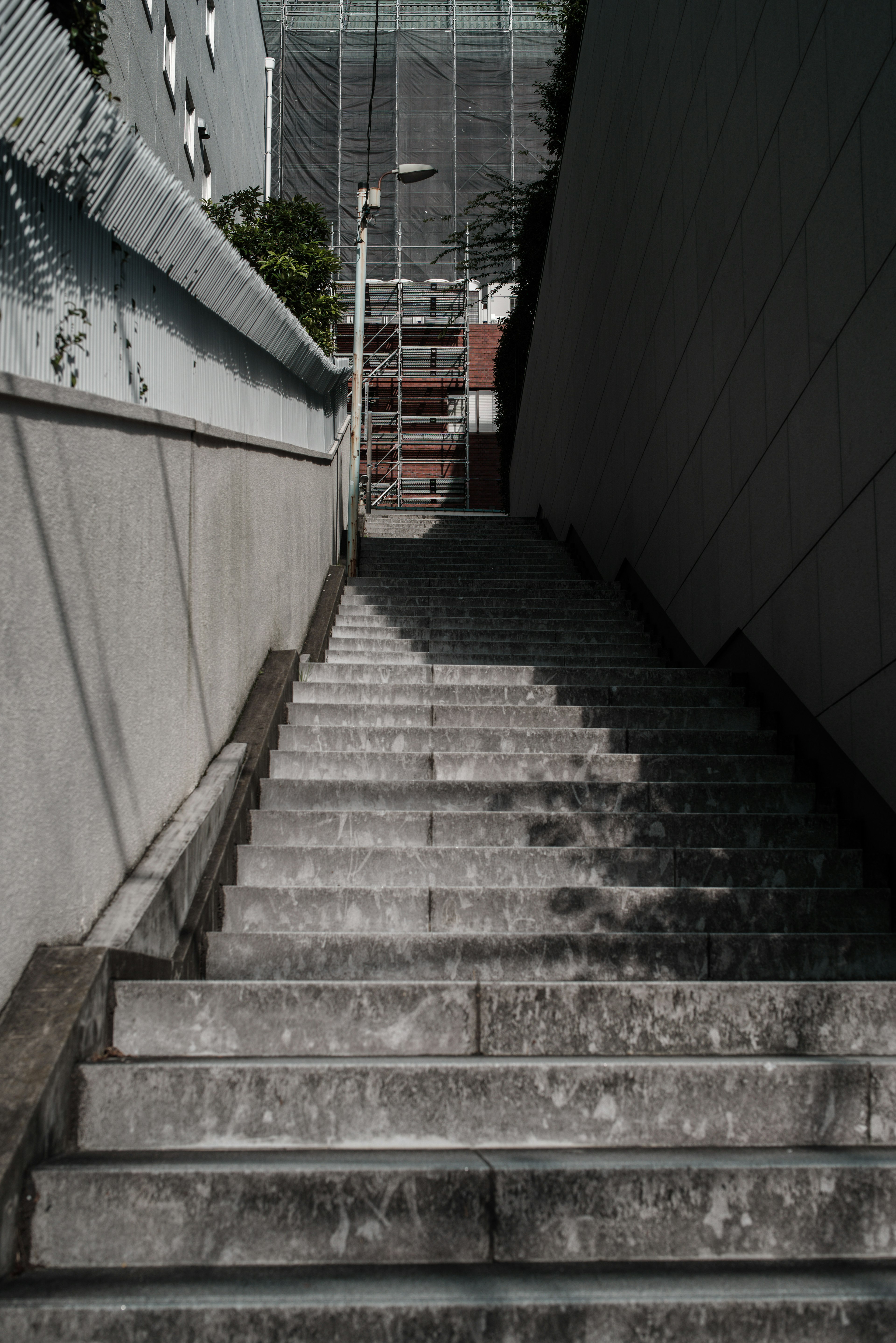 View looking down a concrete staircase with textured walls and shadows