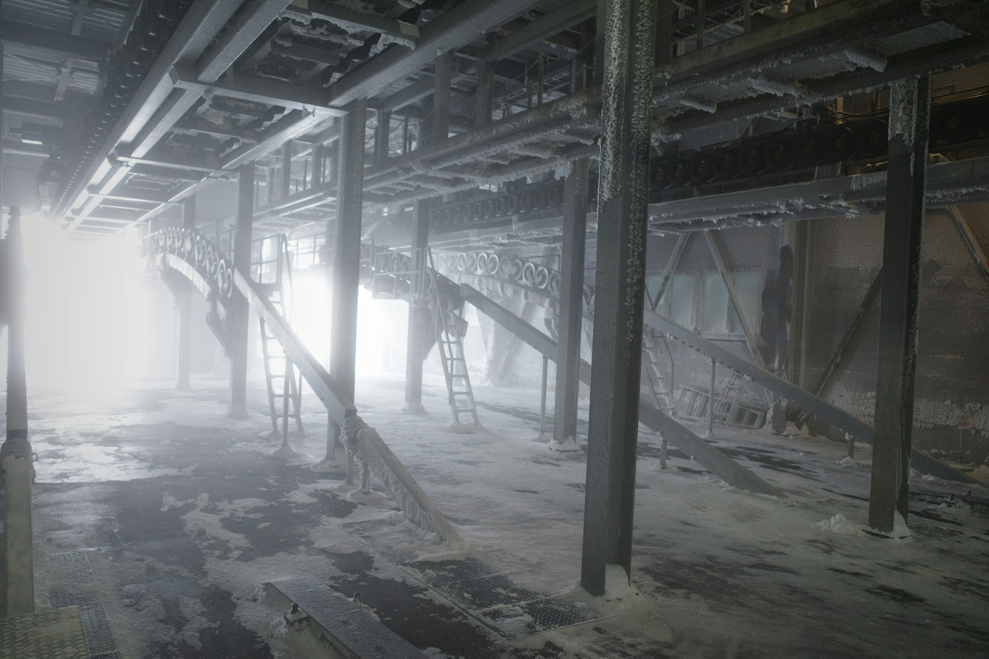 Intérieur d'une usine avec des structures métalliques et une atmosphère brumeuse