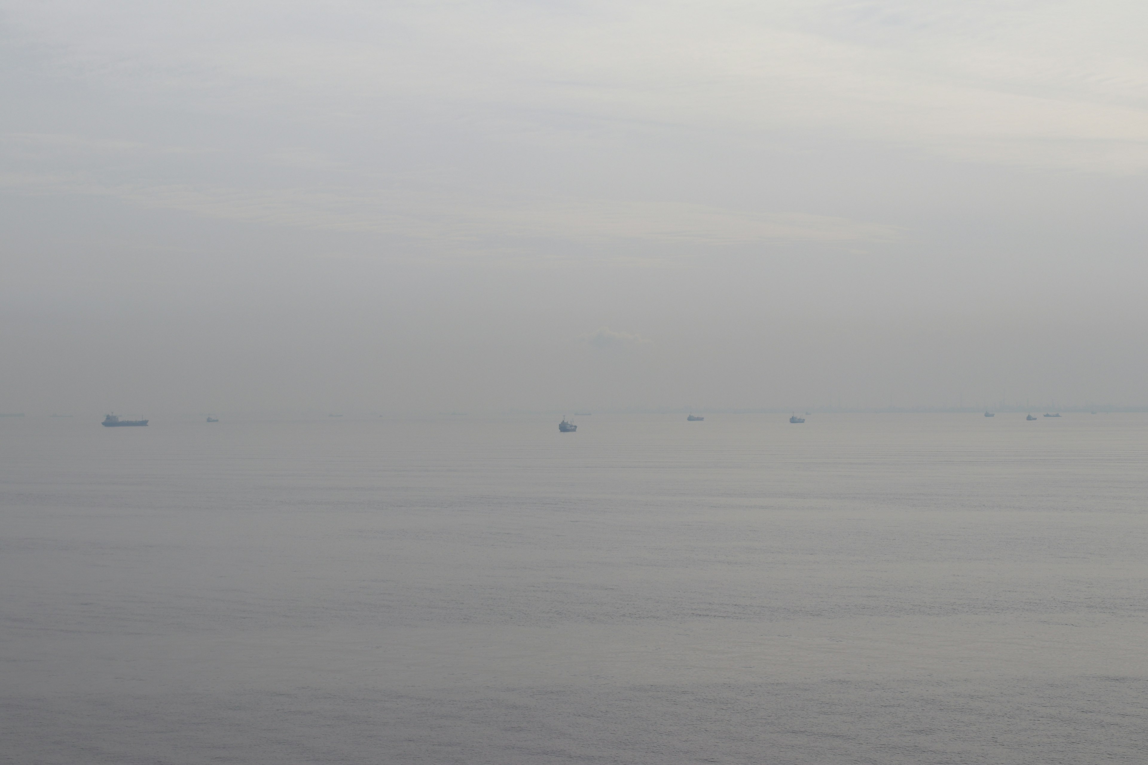 Vista brumosa de barcos flotando en un mar tranquilo