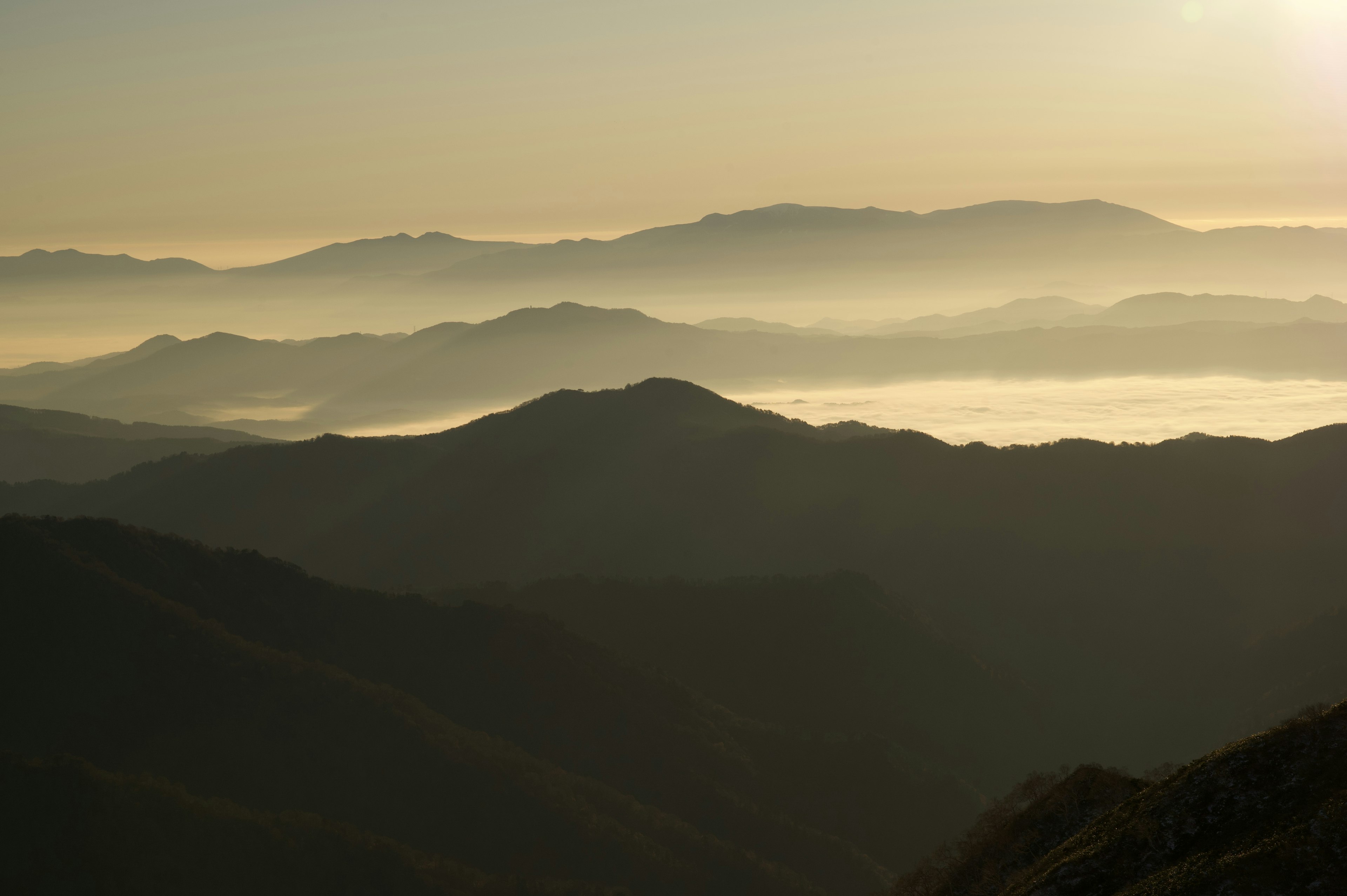 Silhouette von Bergen, die im Nebel bei Sonnenaufgang gehüllt sind