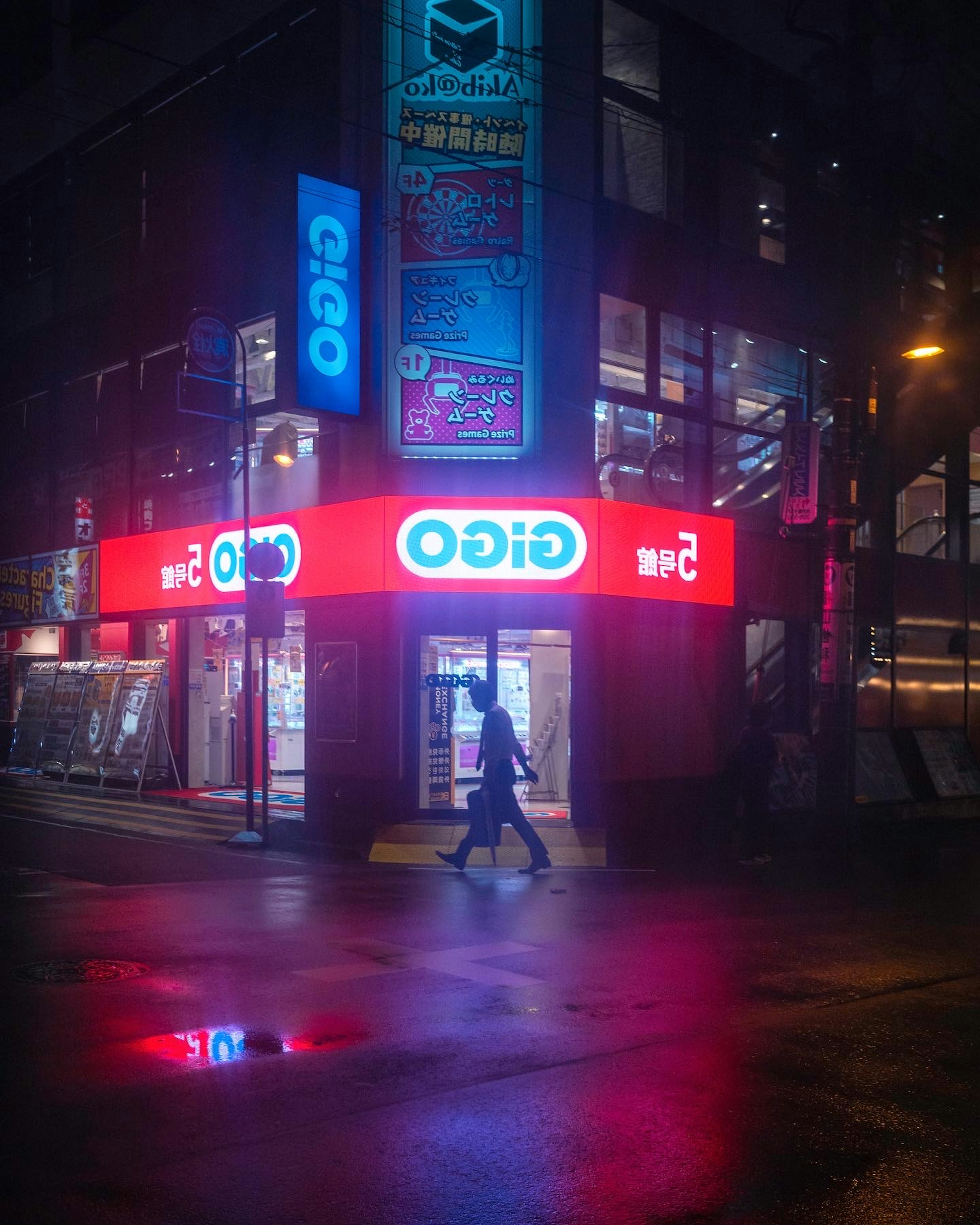 Letrero de neón brillante de una tienda en una esquina de calle lluviosa