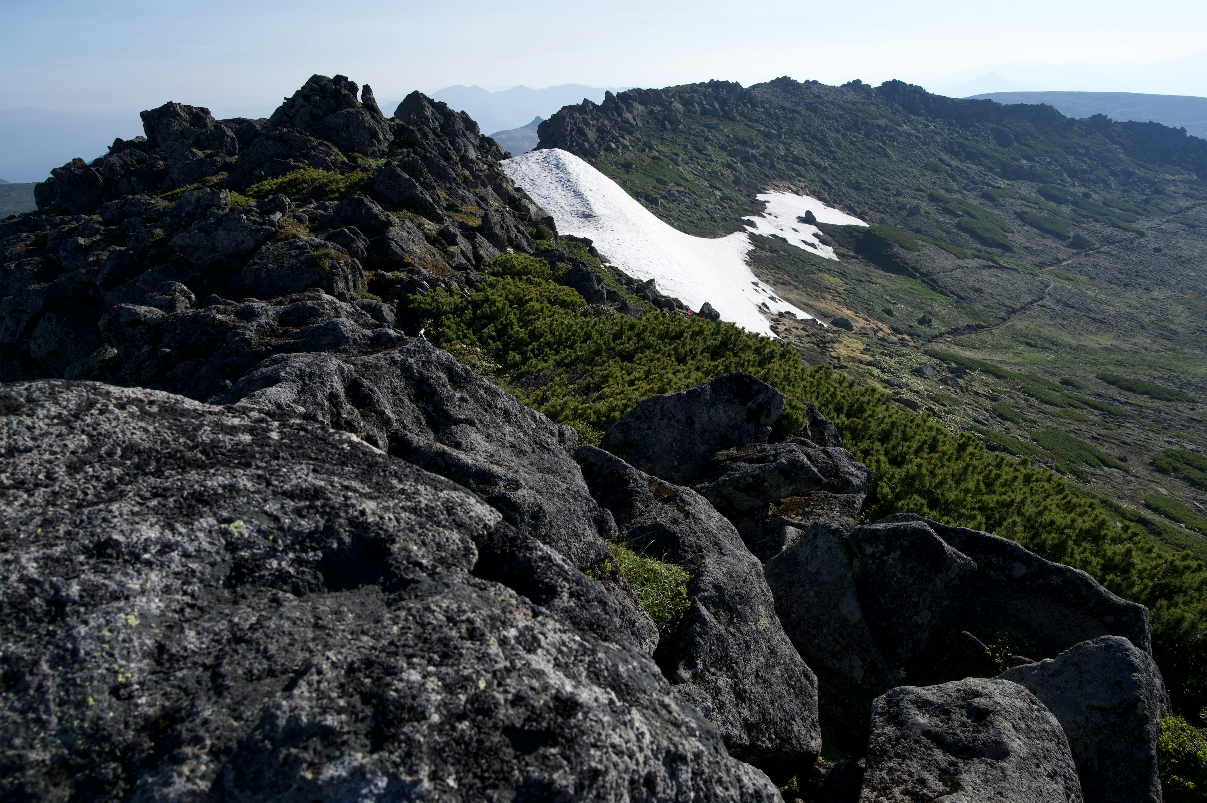 Paysage de montagne avec de la neige restante vu d'un affleurement rocheux