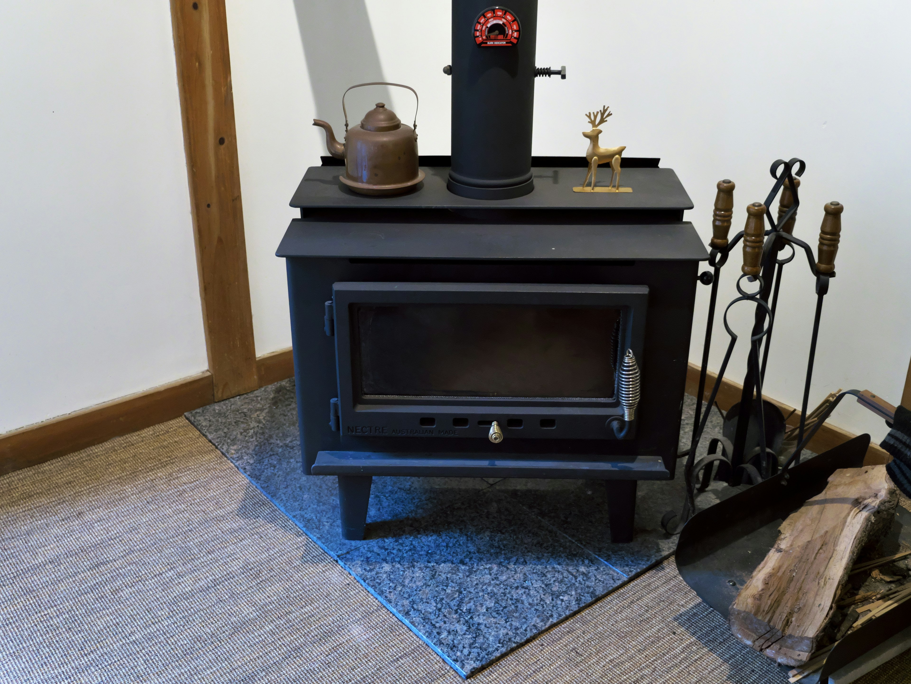 black stove with a kettle and decorative items on top