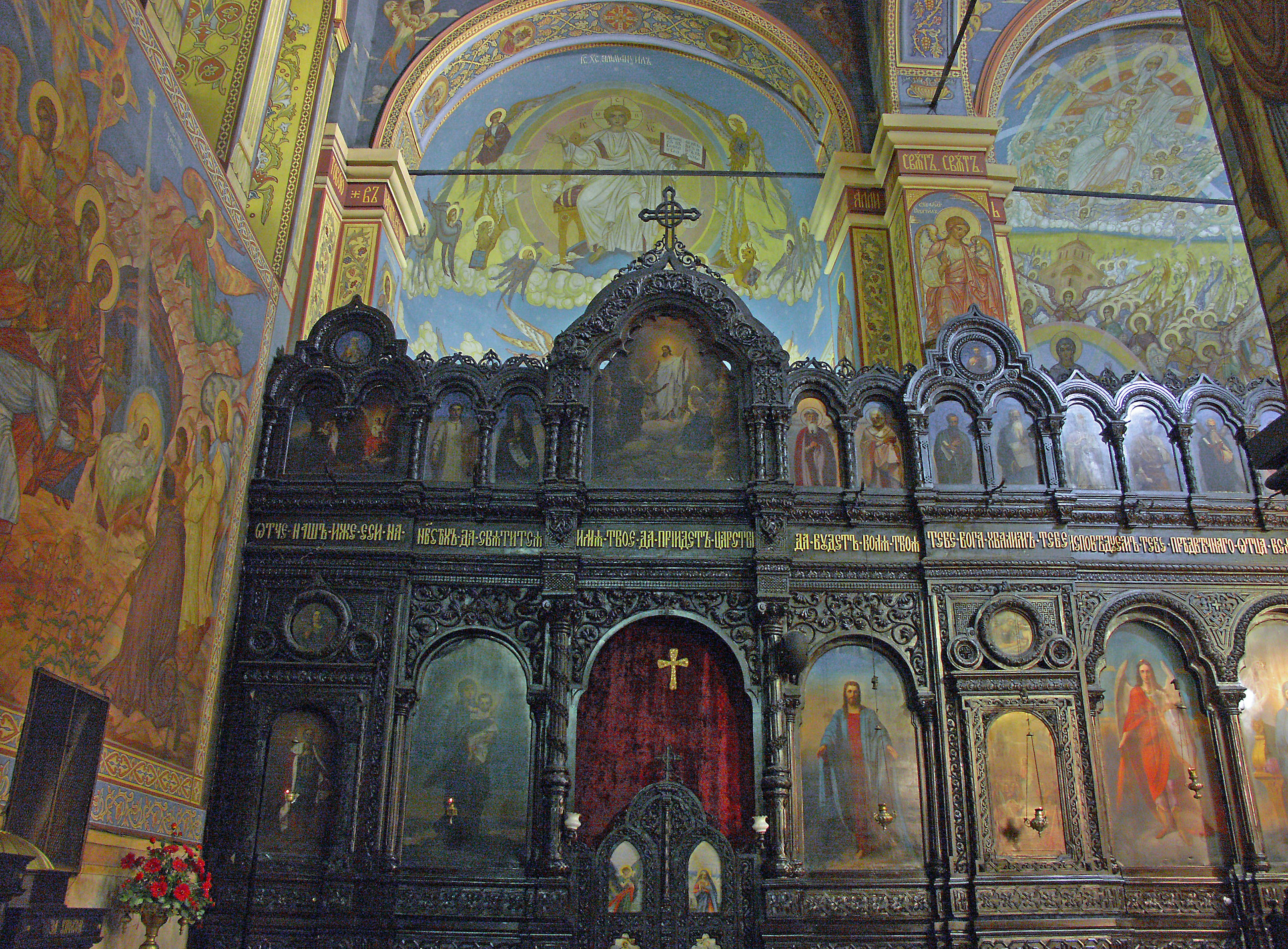 Interior gereja dengan mural indah dan altar kayu yang dihiasi