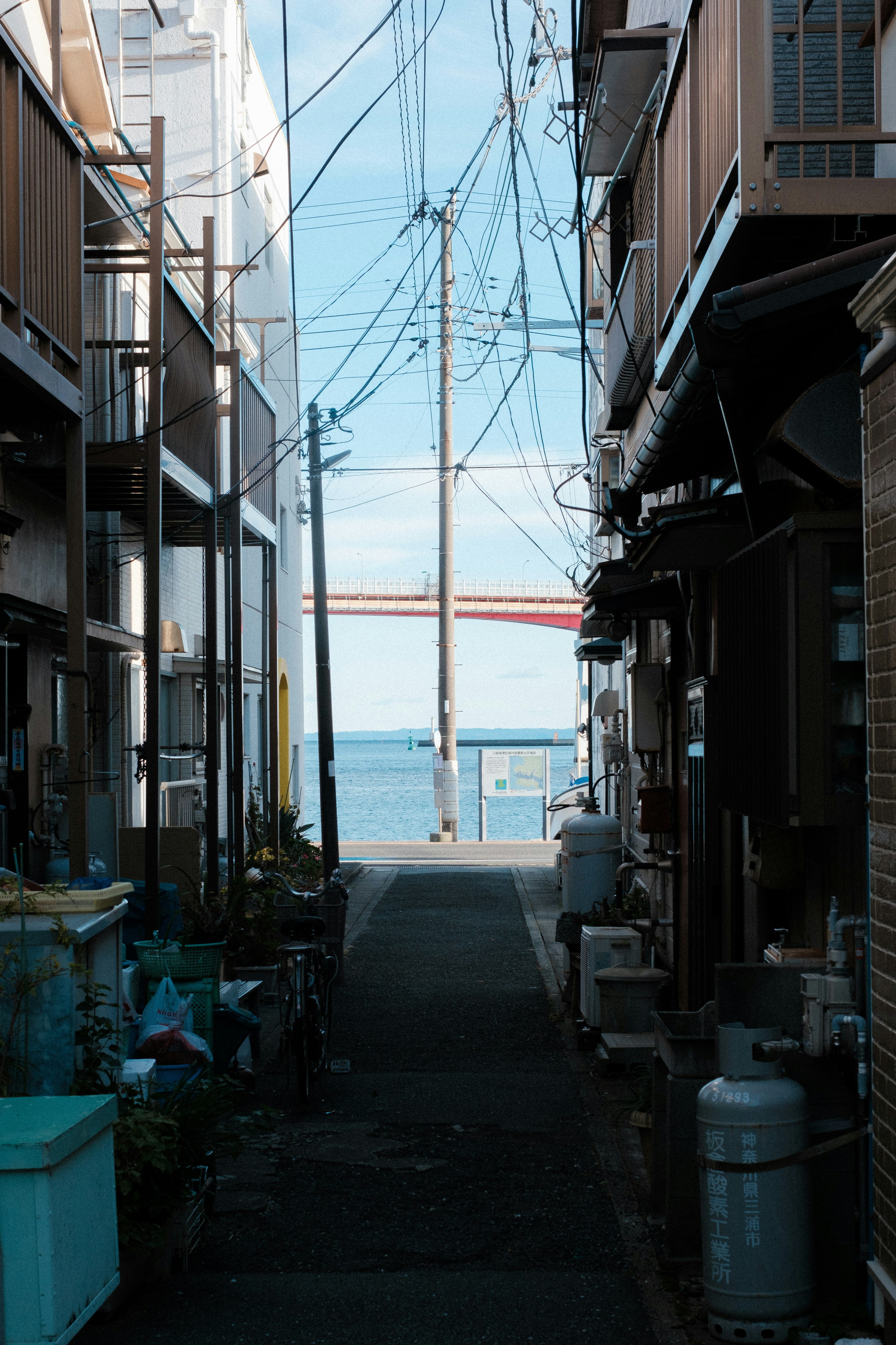 狭い路地の先に海が見える風景 電柱と電線が特徴的