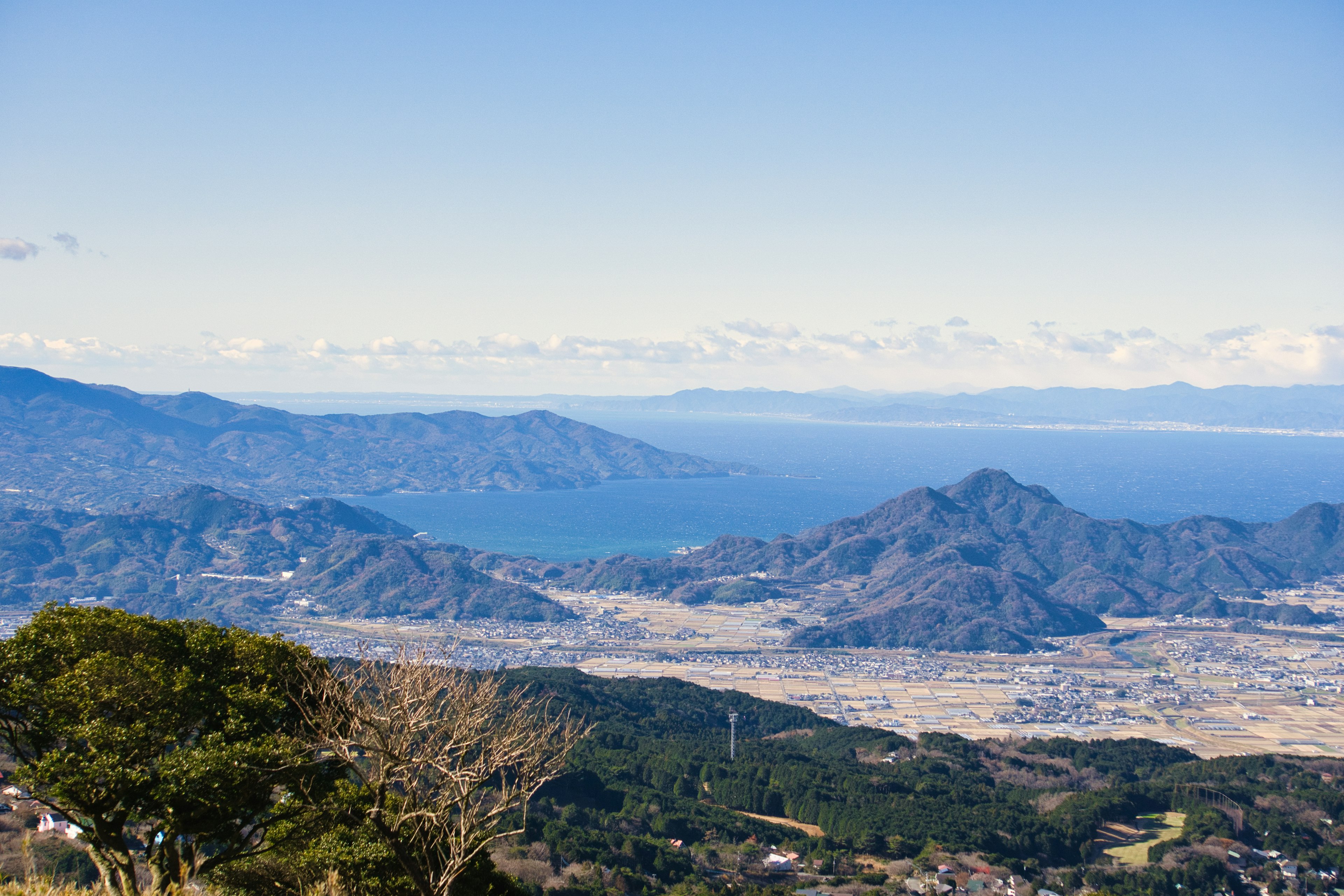 Vue panoramique des montagnes et de l'océan sous un ciel bleu clair