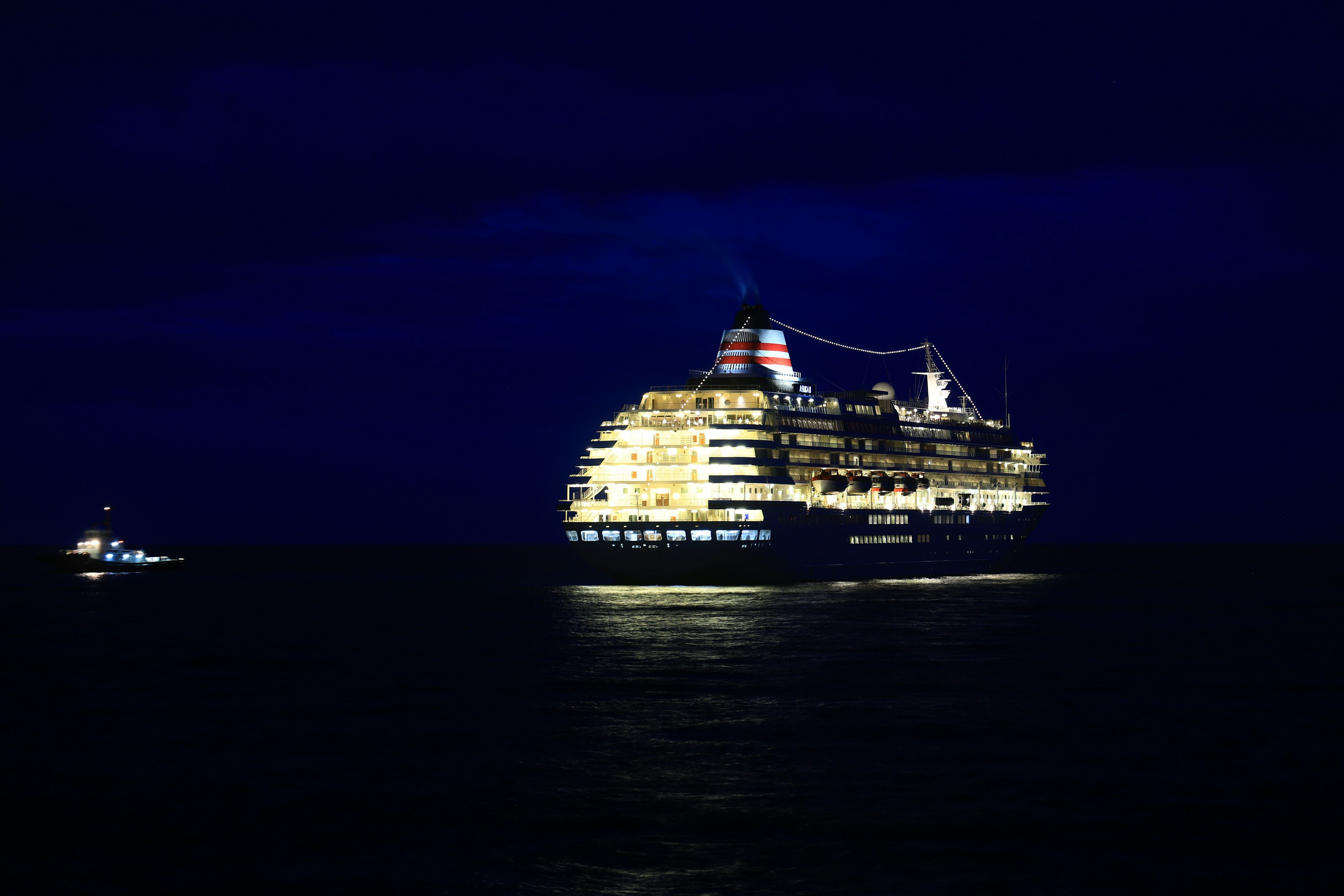 Barco de crucero lujoso iluminado por la noche en el océano