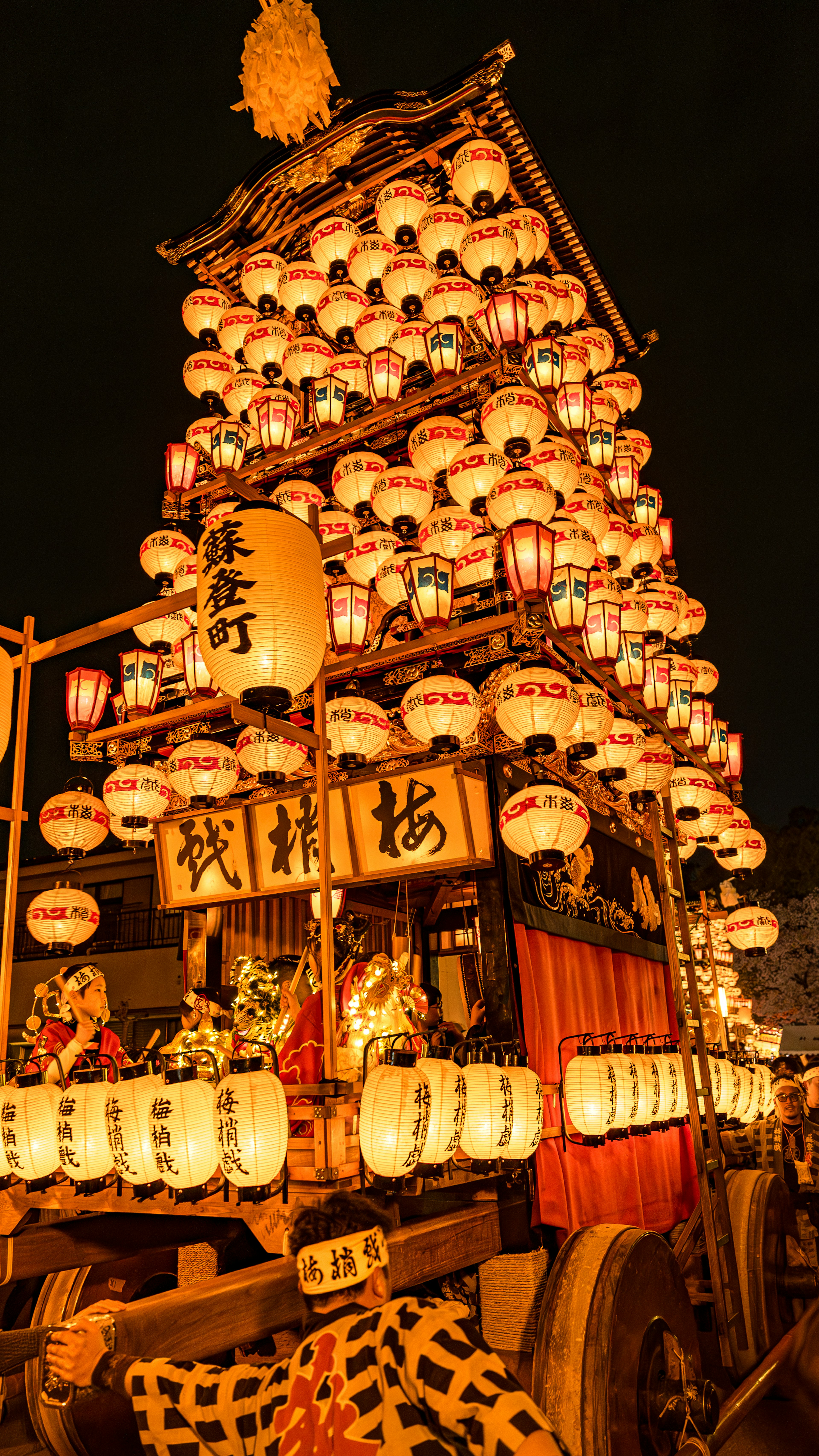 Festival float adorned with glowing lanterns at night