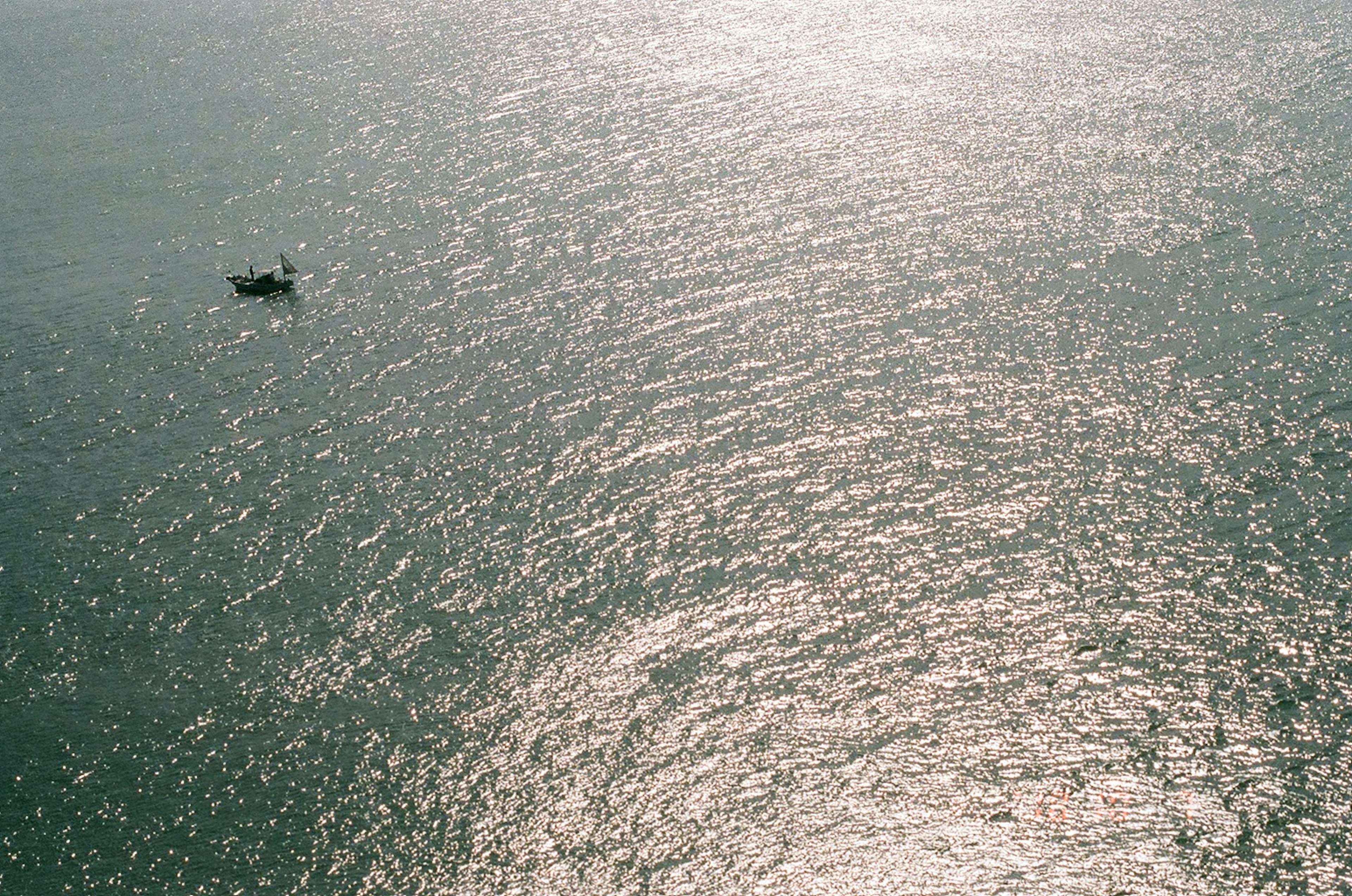 Ein kleines Boot, das auf dem Ozean schwimmt und mit Licht reflektiert