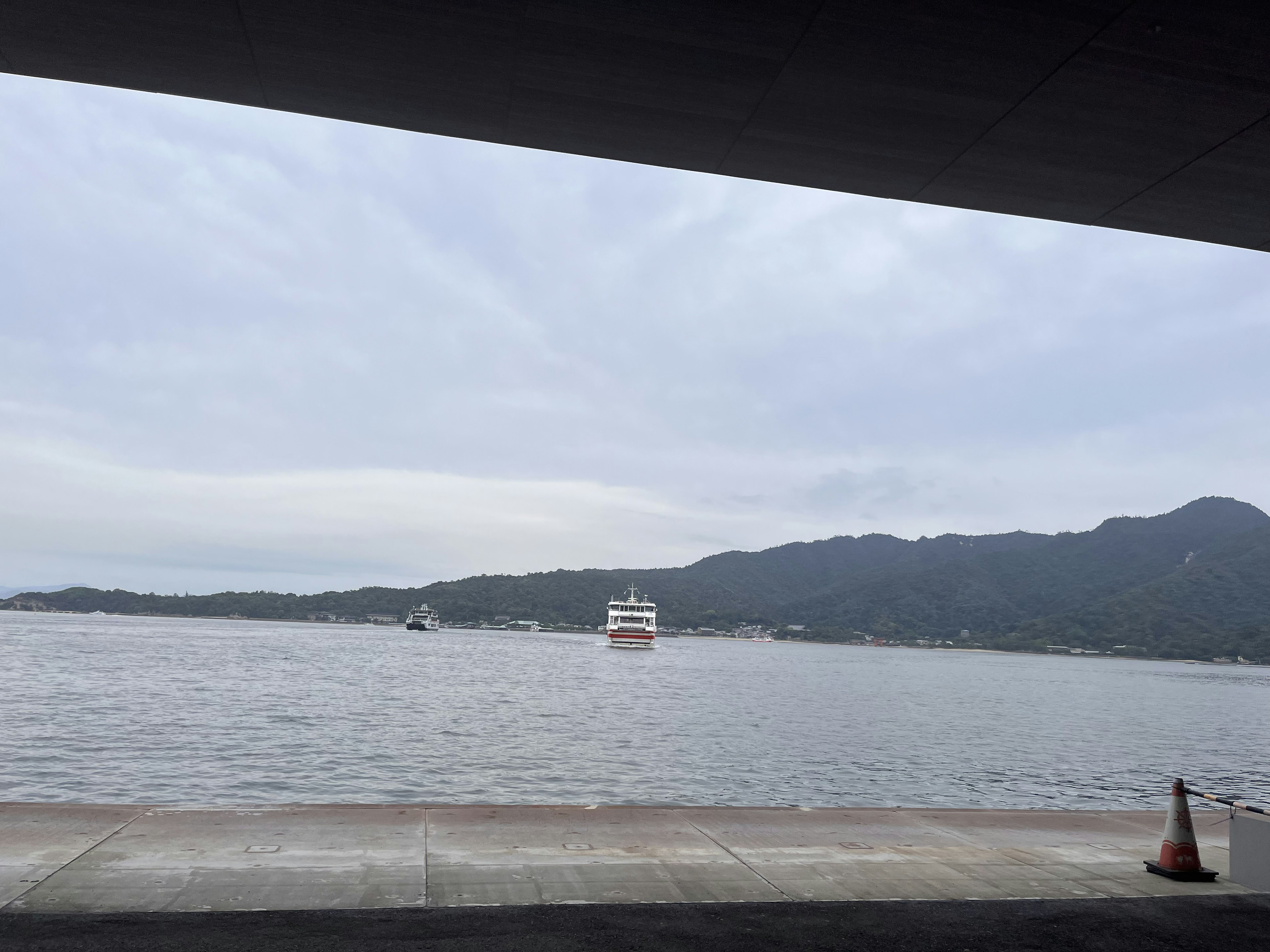 View of a harbor with mountains and a boat on the water