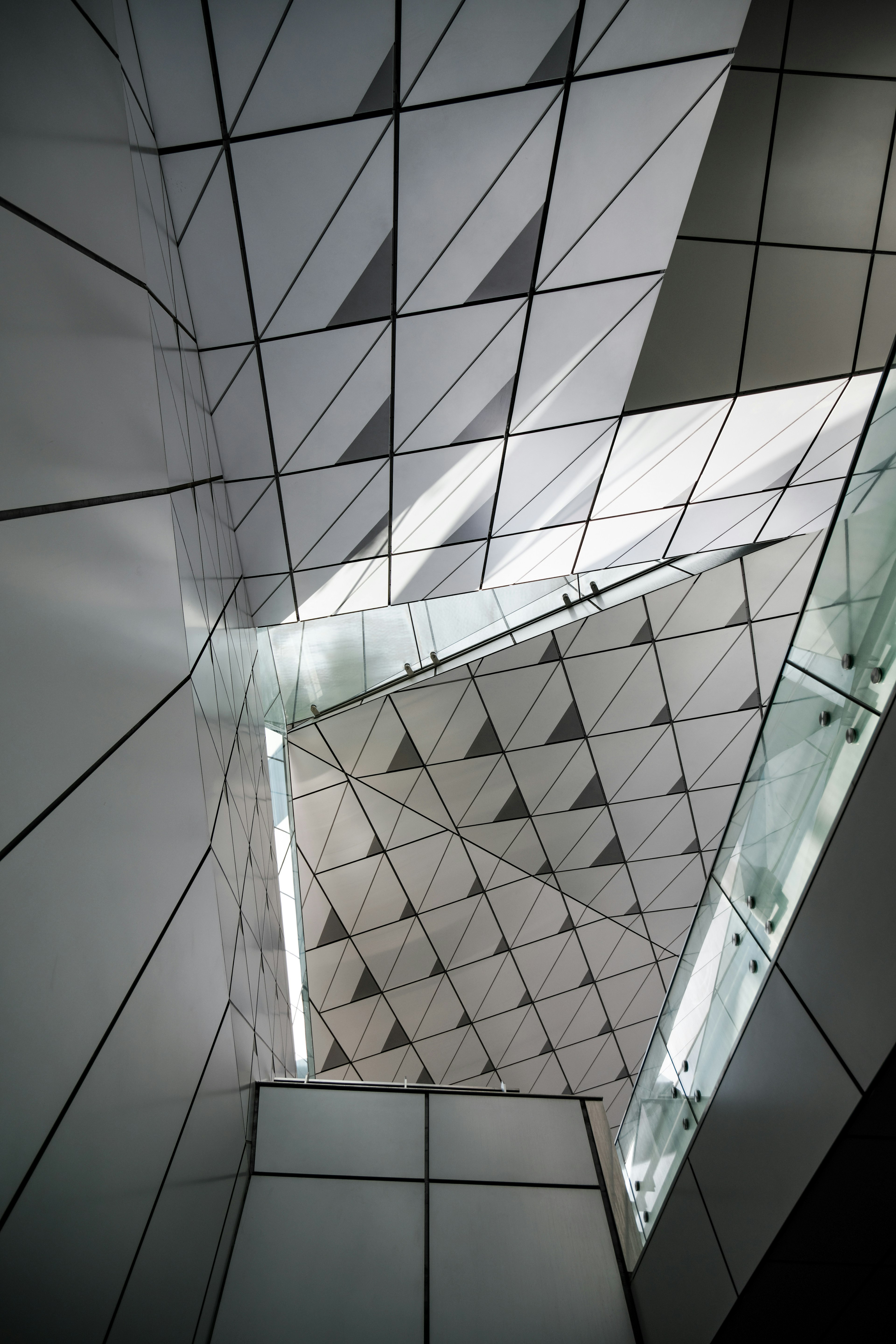 Interior of a modern building featuring geometric white walls and light reflections