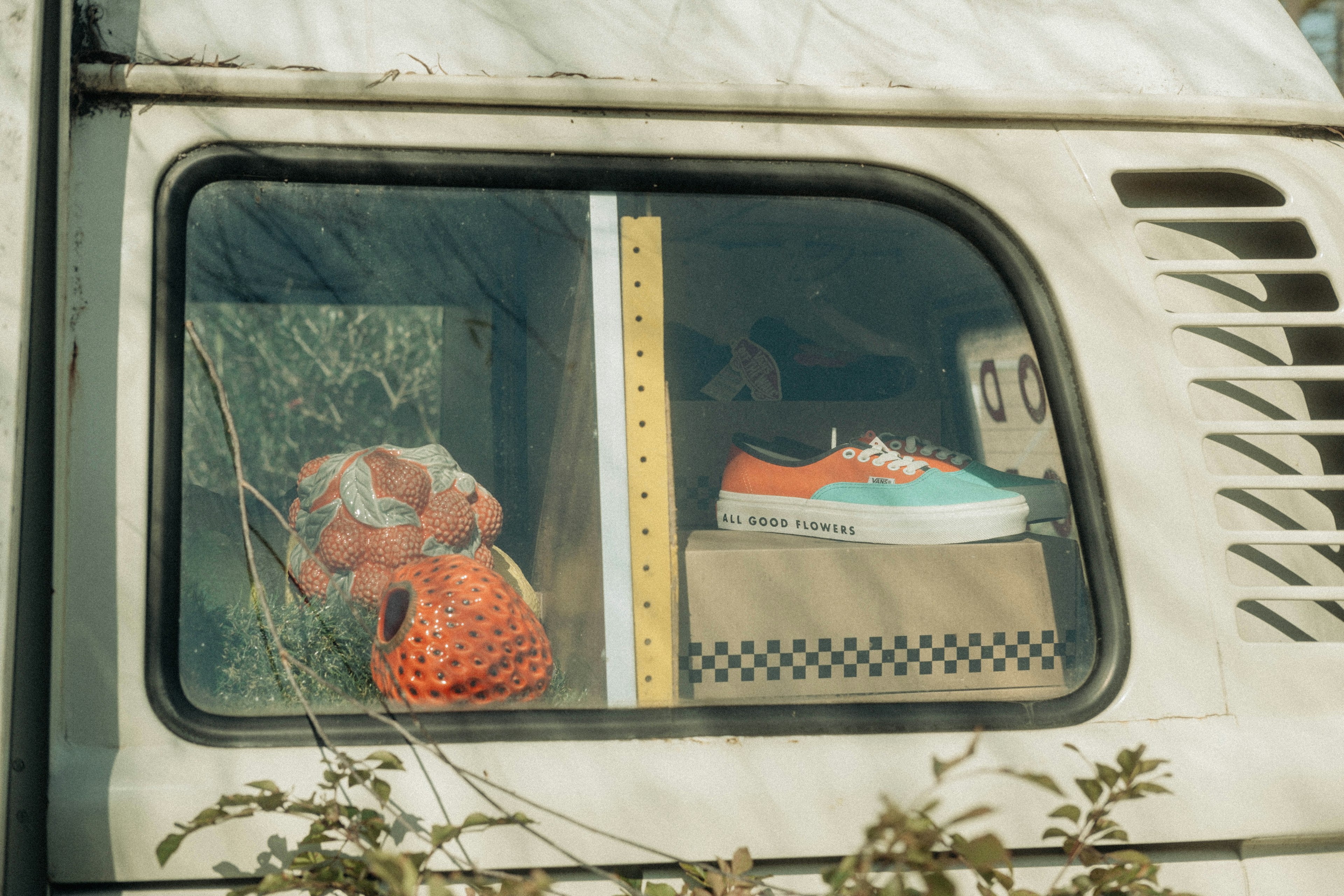 Image of a camper van window featuring a red stuffed animal and sneakers