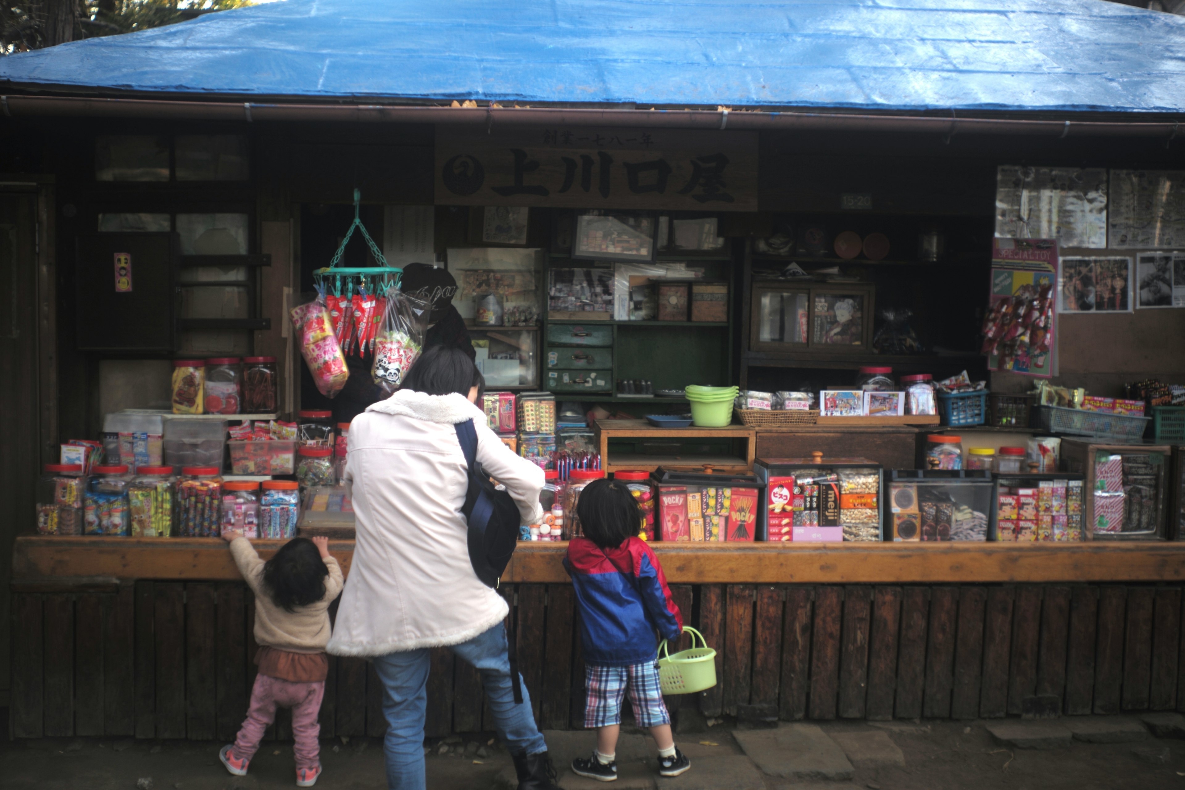 Children exploring a market stall with various products