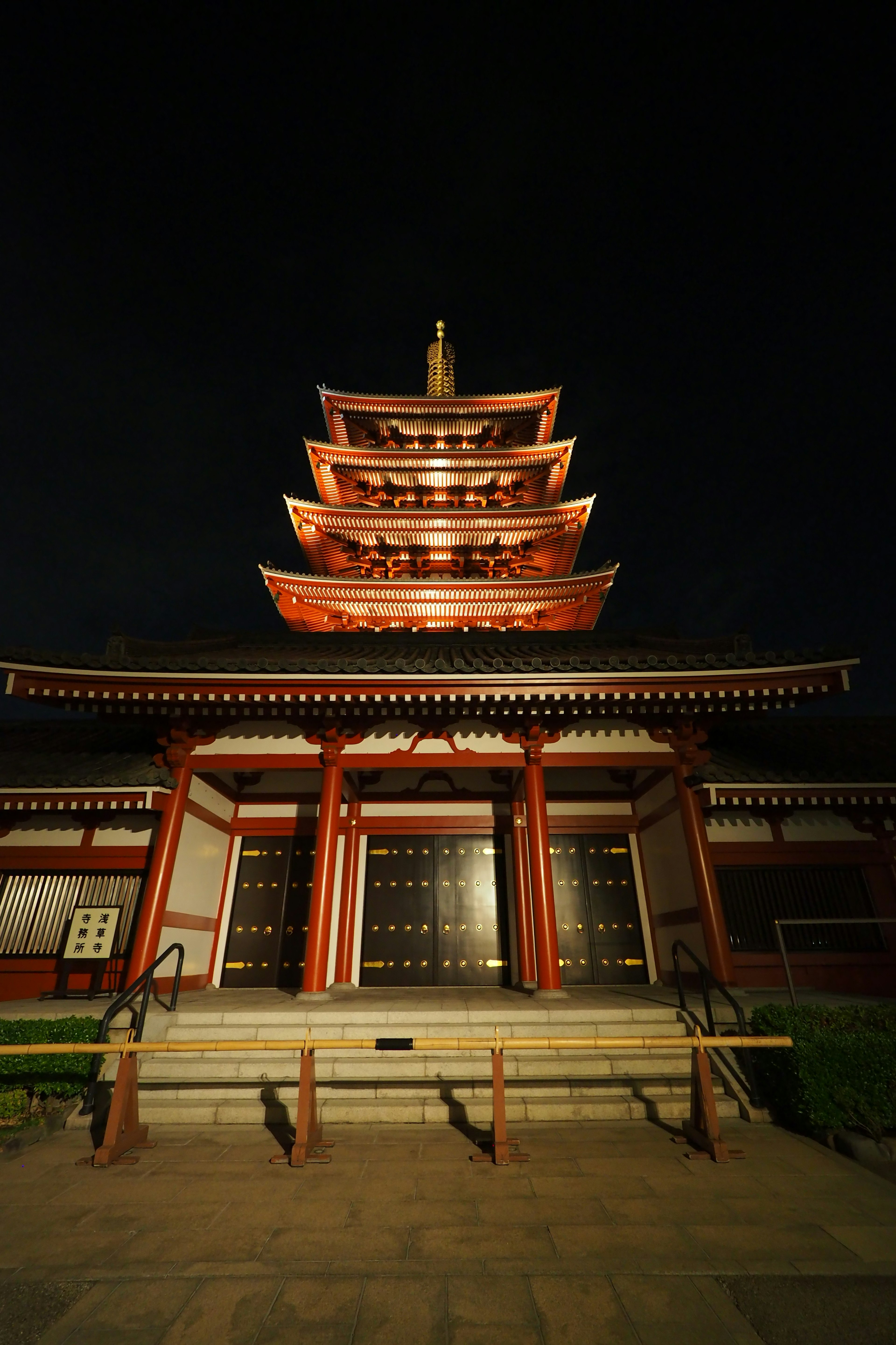 Struktur pagoda yang indah diterangi pada malam hari dengan eksterior merah