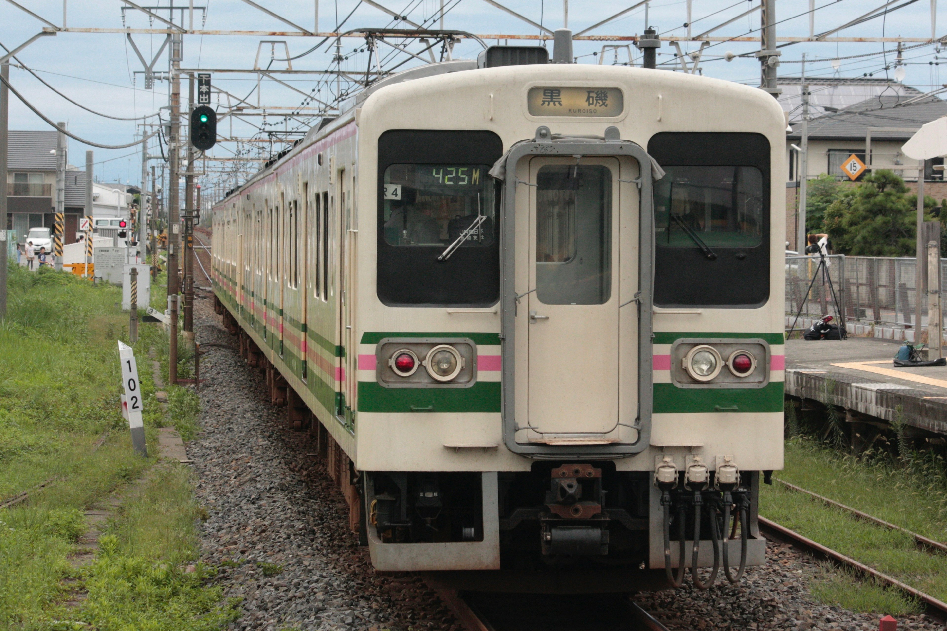 緑と白の電車が駅に停車している風景