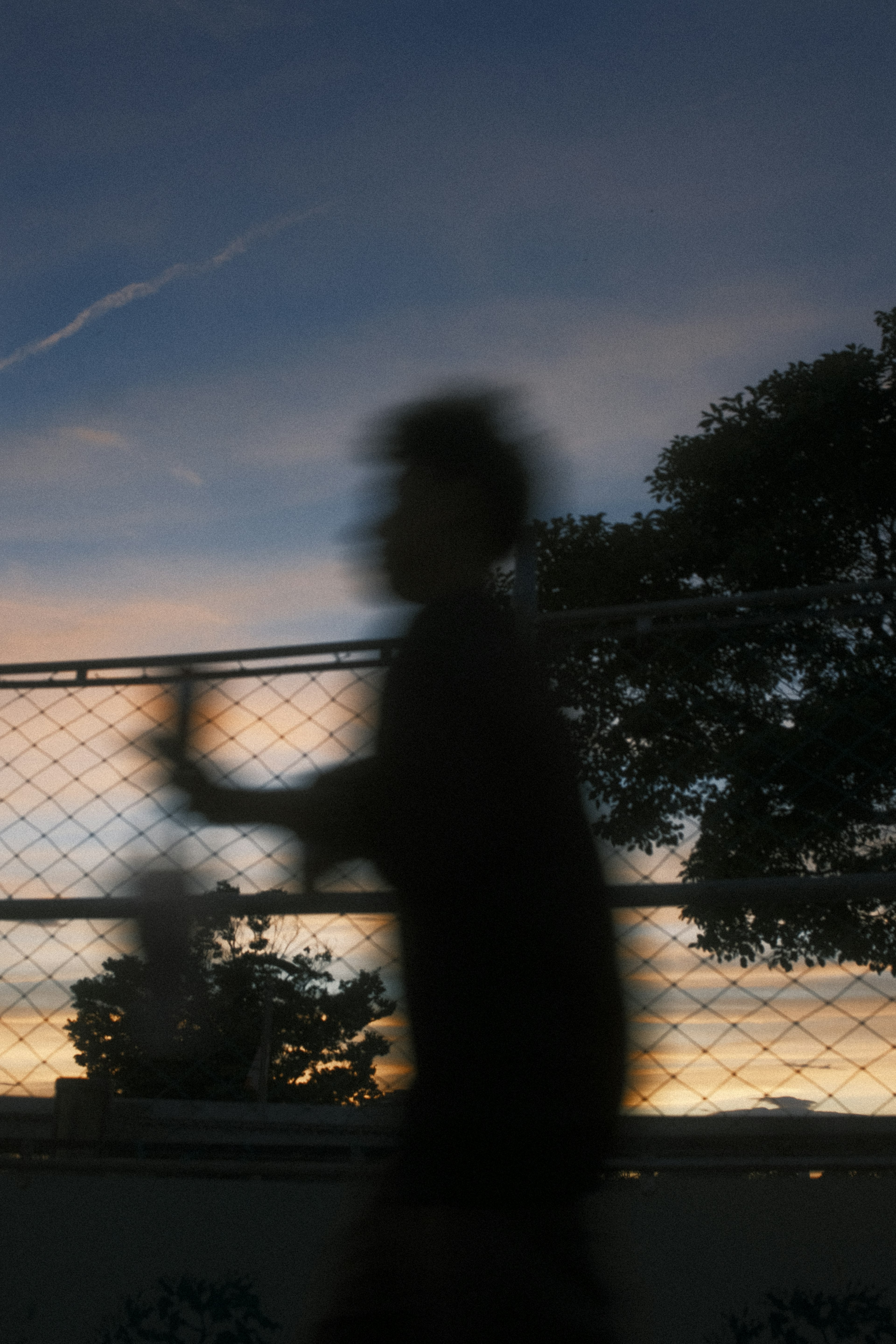 Schatten einer Person, die gegen einen Sonnenuntergang läuft