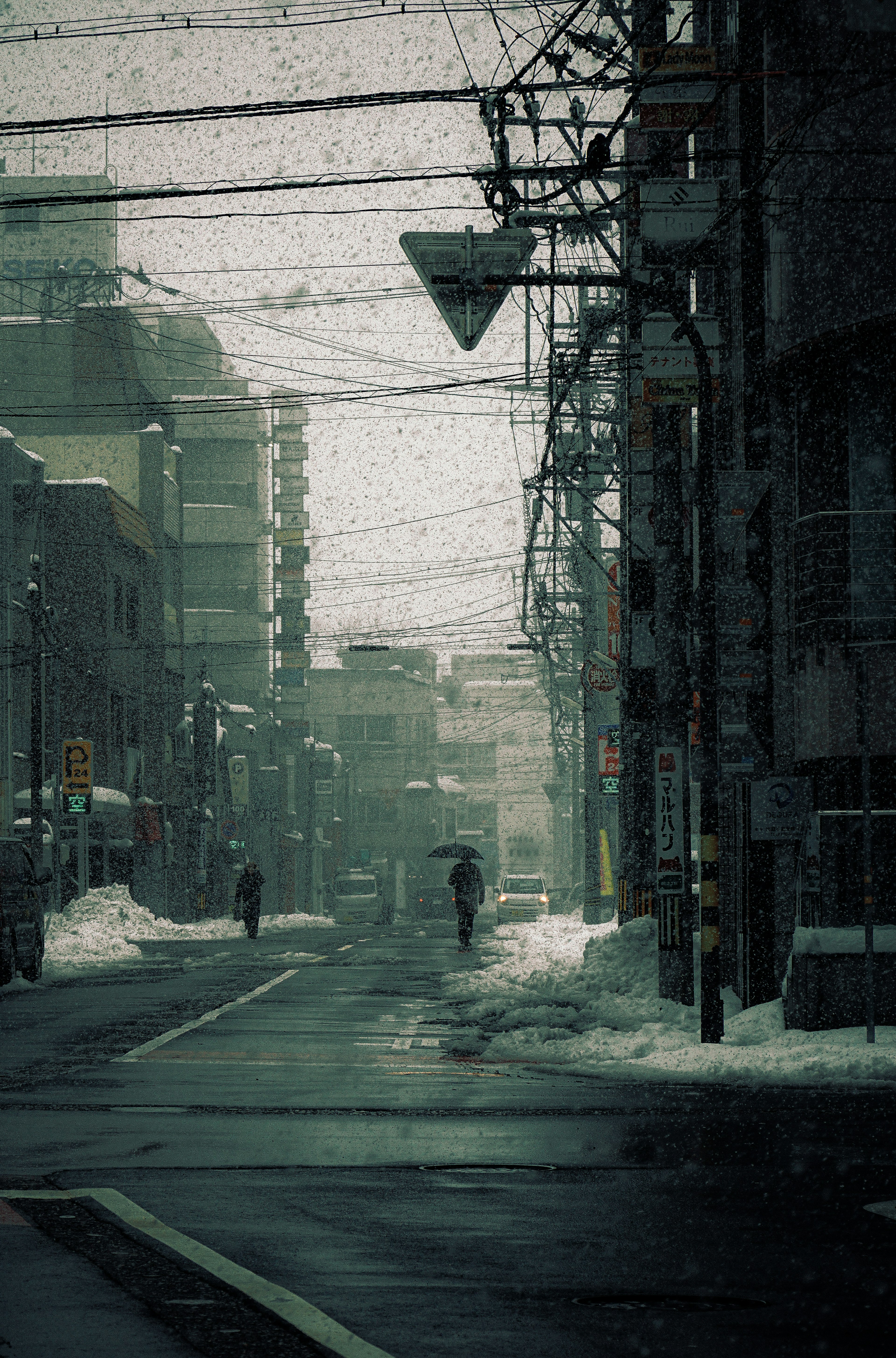 Snowy street scene with buildings and power lines