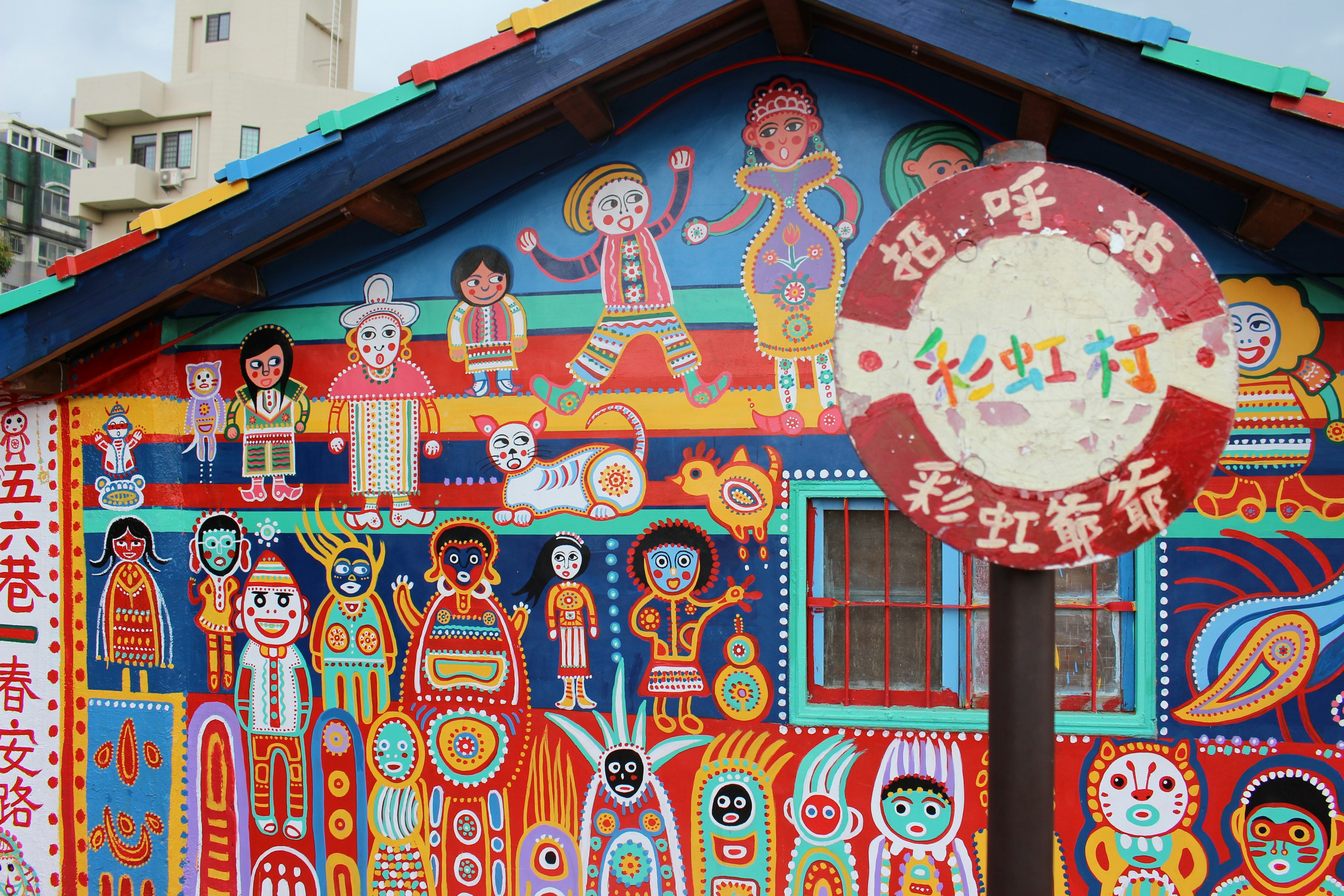 Colorful mural on a house featuring various characters and patterns