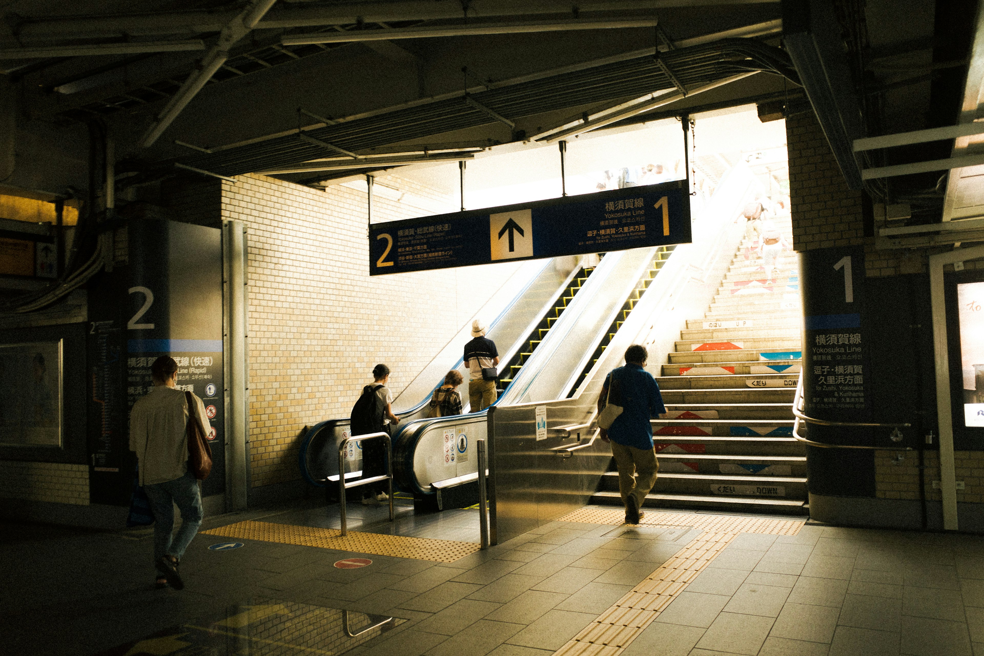 Interior of a train station with people moving towards bright light