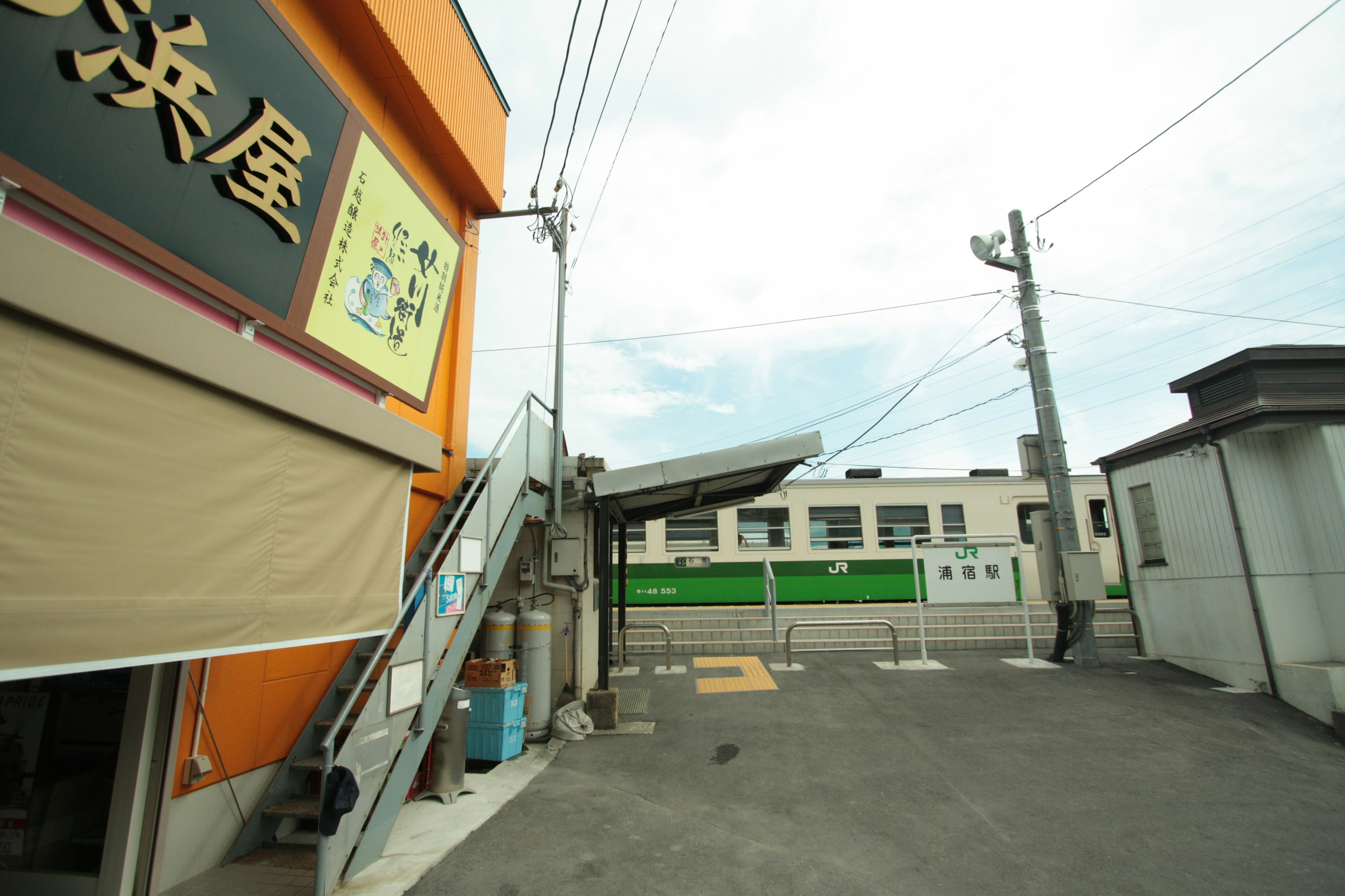 View of an orange building with a staircase and nearby train tracks